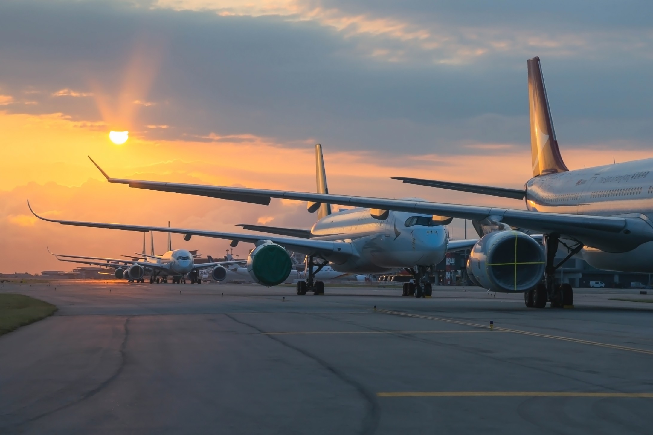 Airliners parked on the tarmac at sunset as FAA flight cuts begin during the government shutdown