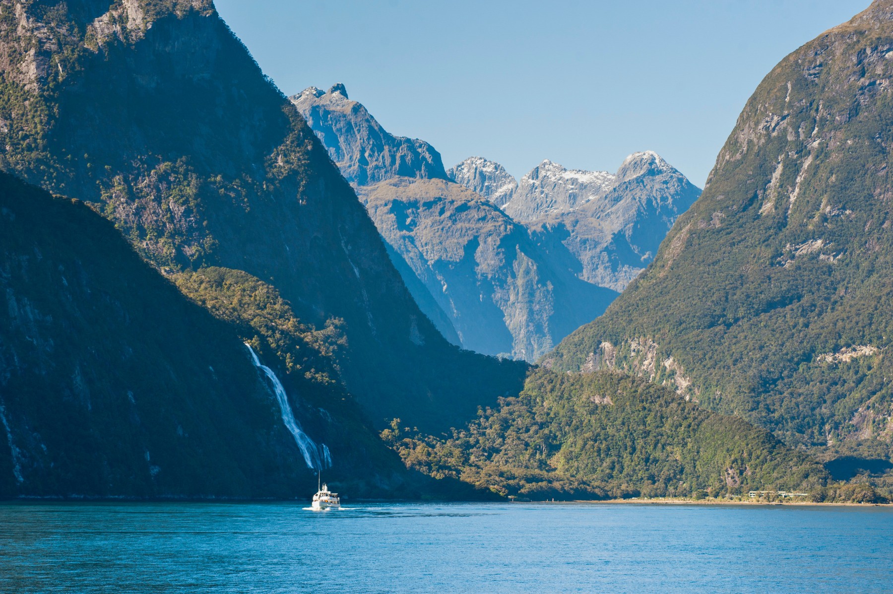 Cruise ship sailing through a scenic fjord, representing first-time cruisers learning how to avoid common cruise mistakes.