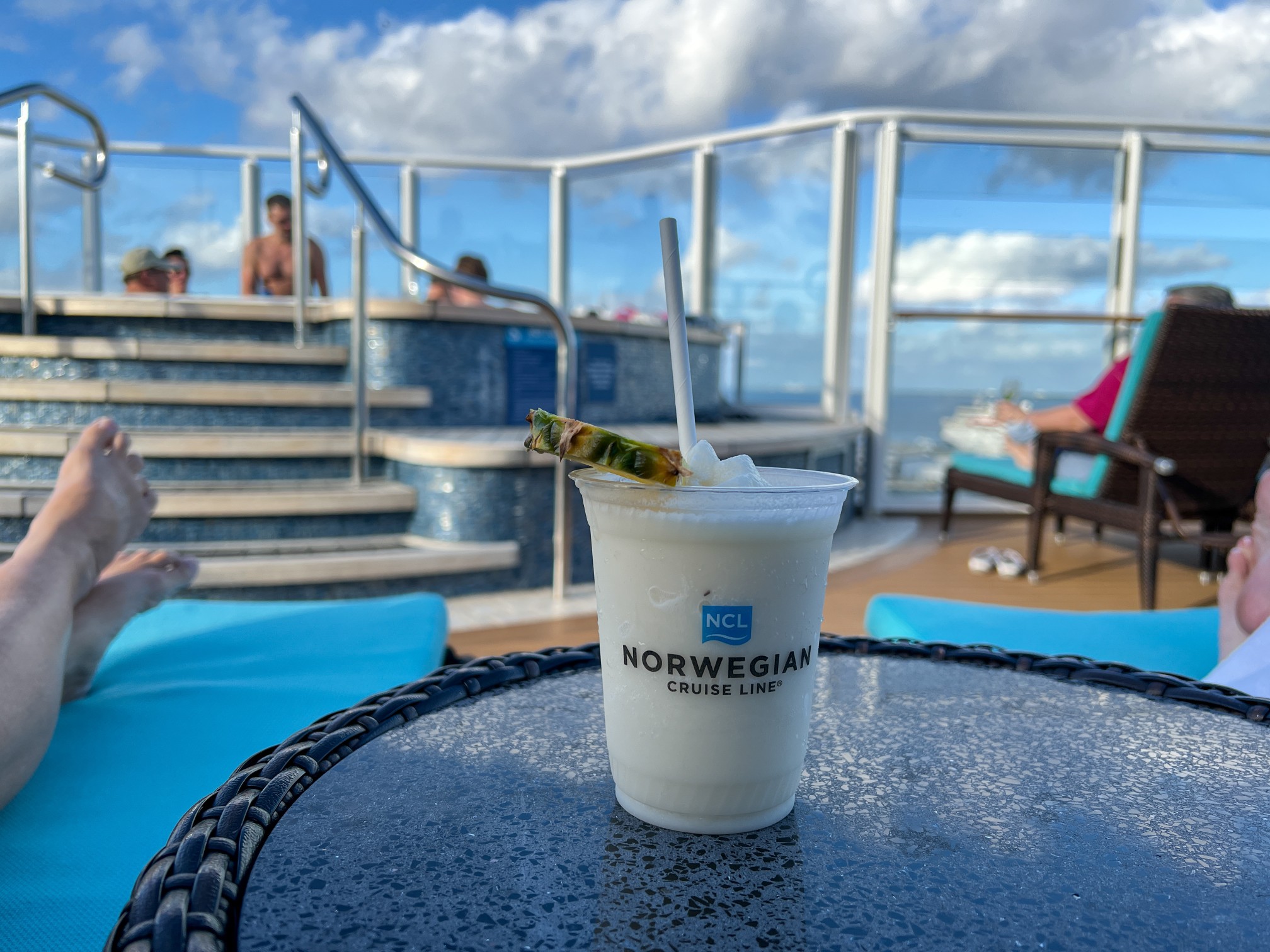A freshly made Pina Colada with bokeh on The Haven sundeck area on the Norwegian Escape cruise ship.