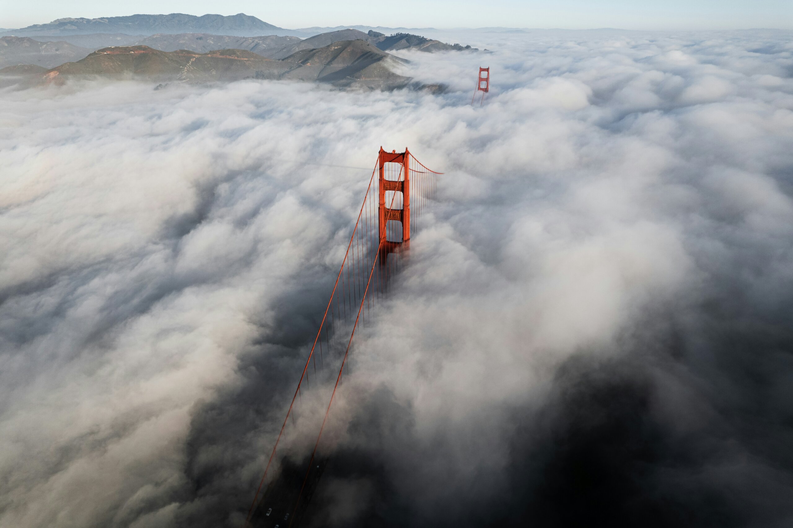 Golden Gate Bridge emerging through dense fog, symbolizing climate risks facing U.S. cities that could become unlivable by 2040.