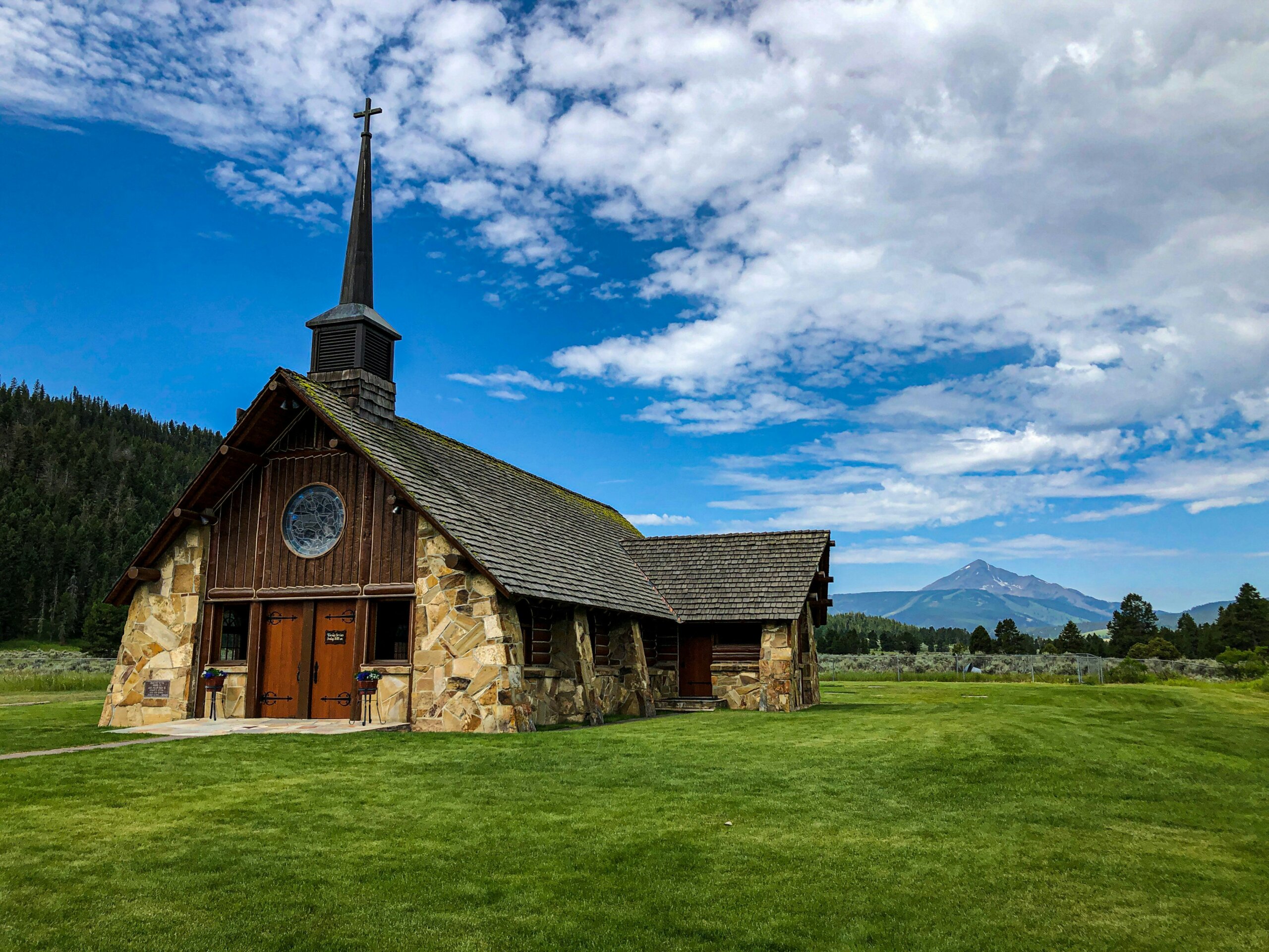 Rustic wooden chapel in Big Sky Montana with mountains and blue sky