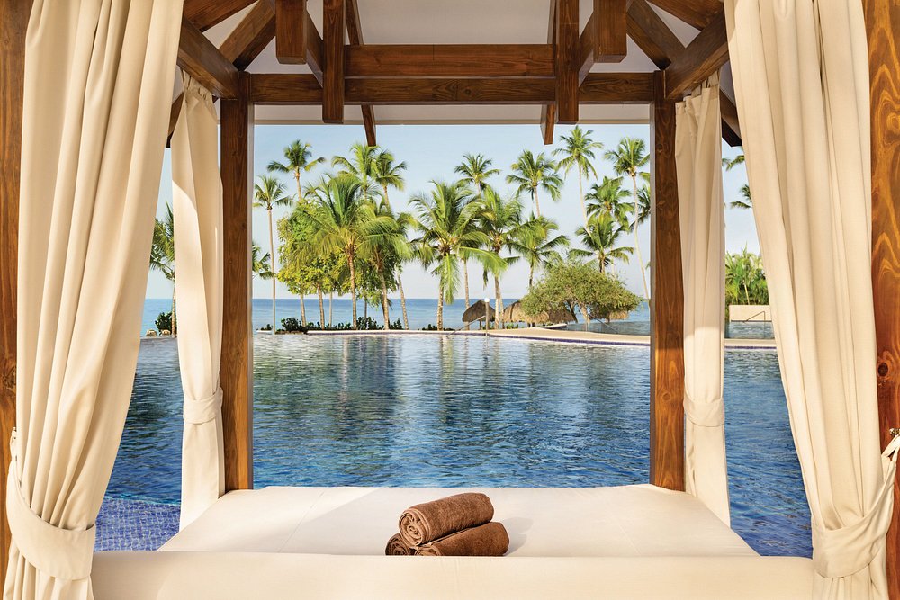 Poolside cabana overlooking infinity pool and palm trees at Secrets La Romana Resort & Spa