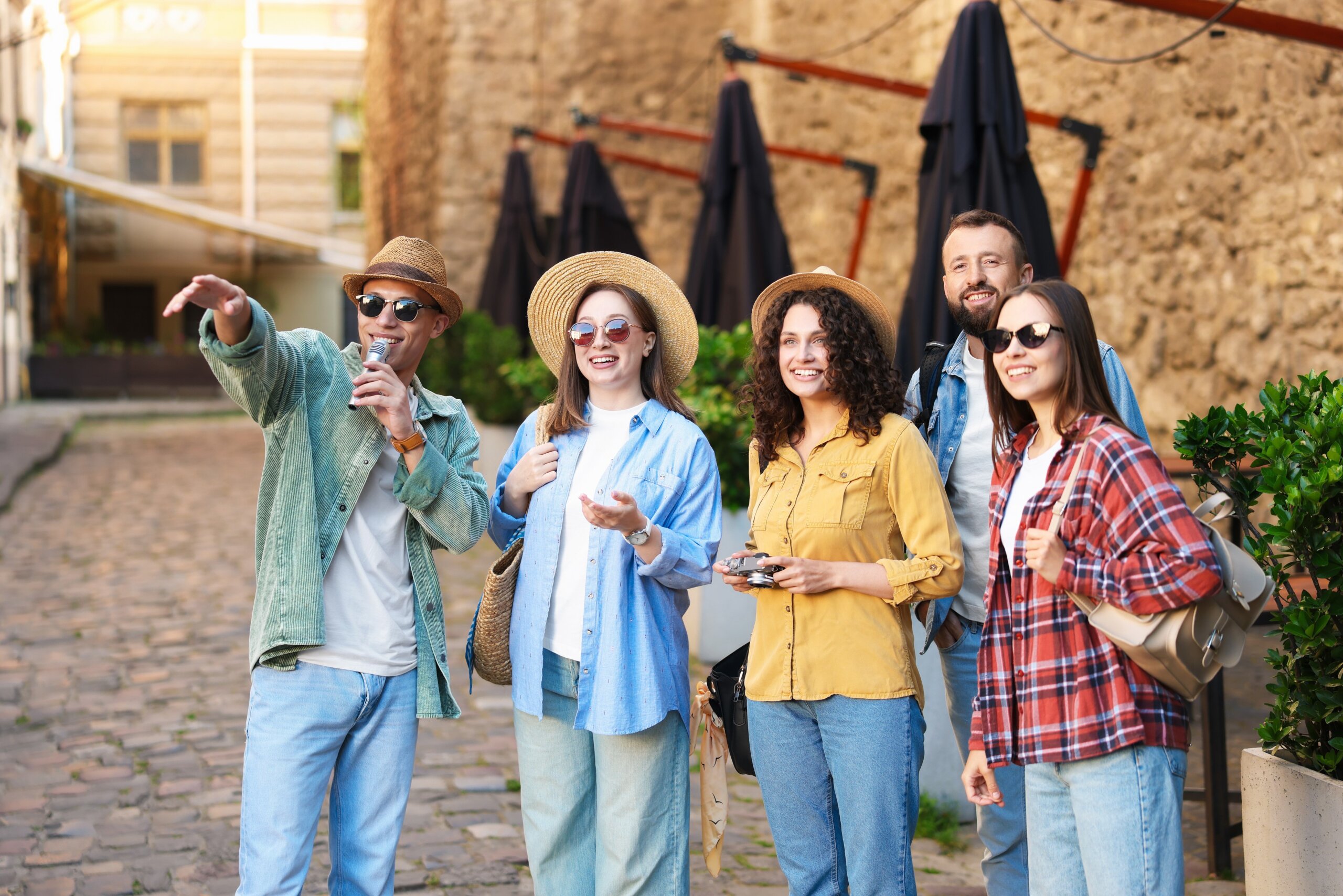Guide with microphone and group of tourists on city street during excursion
