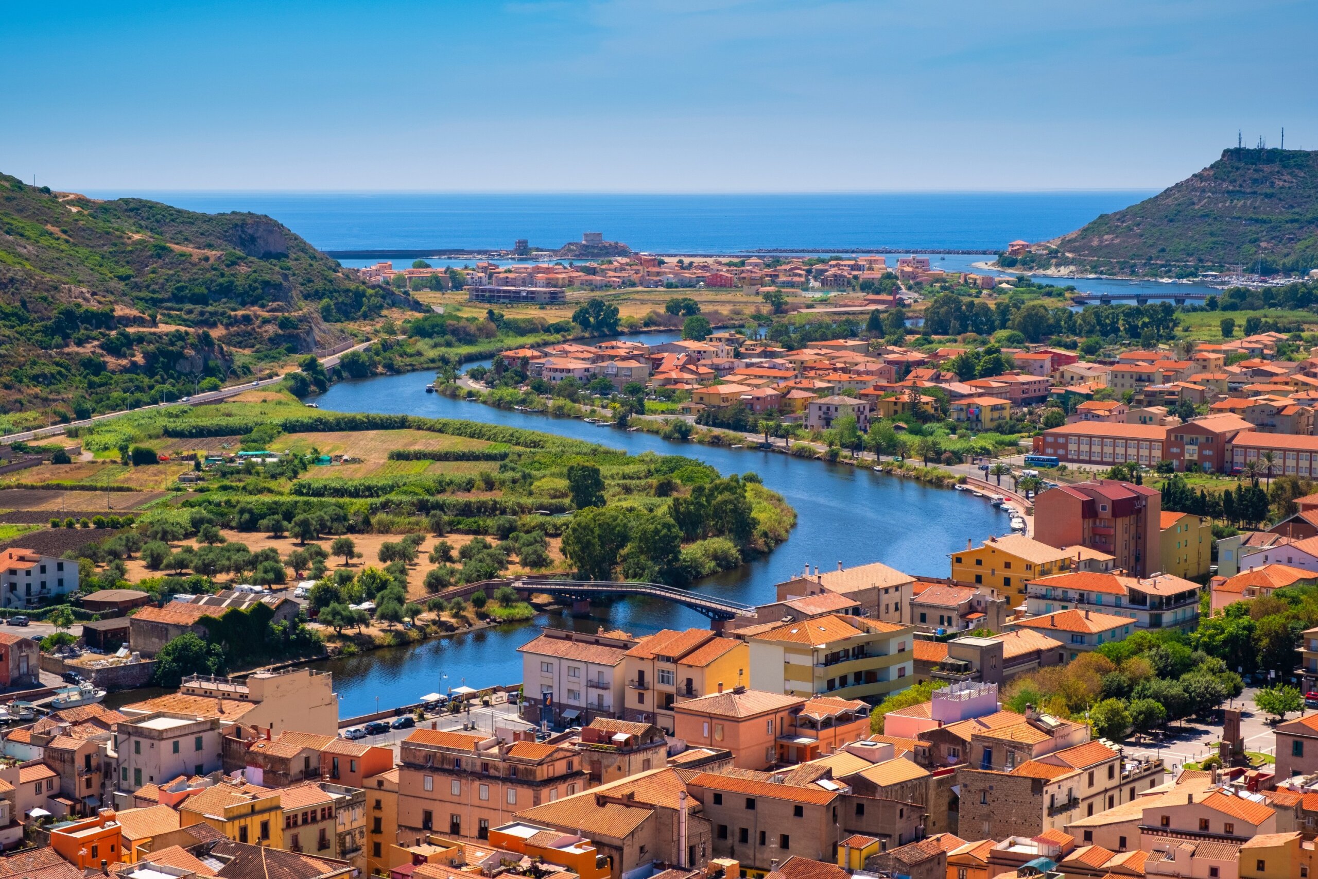 Sardinia, Italy - Panoramic view of the town of Bosa by the Temo river with Bosa Marina resort at the Mediterranean sea coast seen from Malaspina Castle hill - known also as Castle of Serravalle