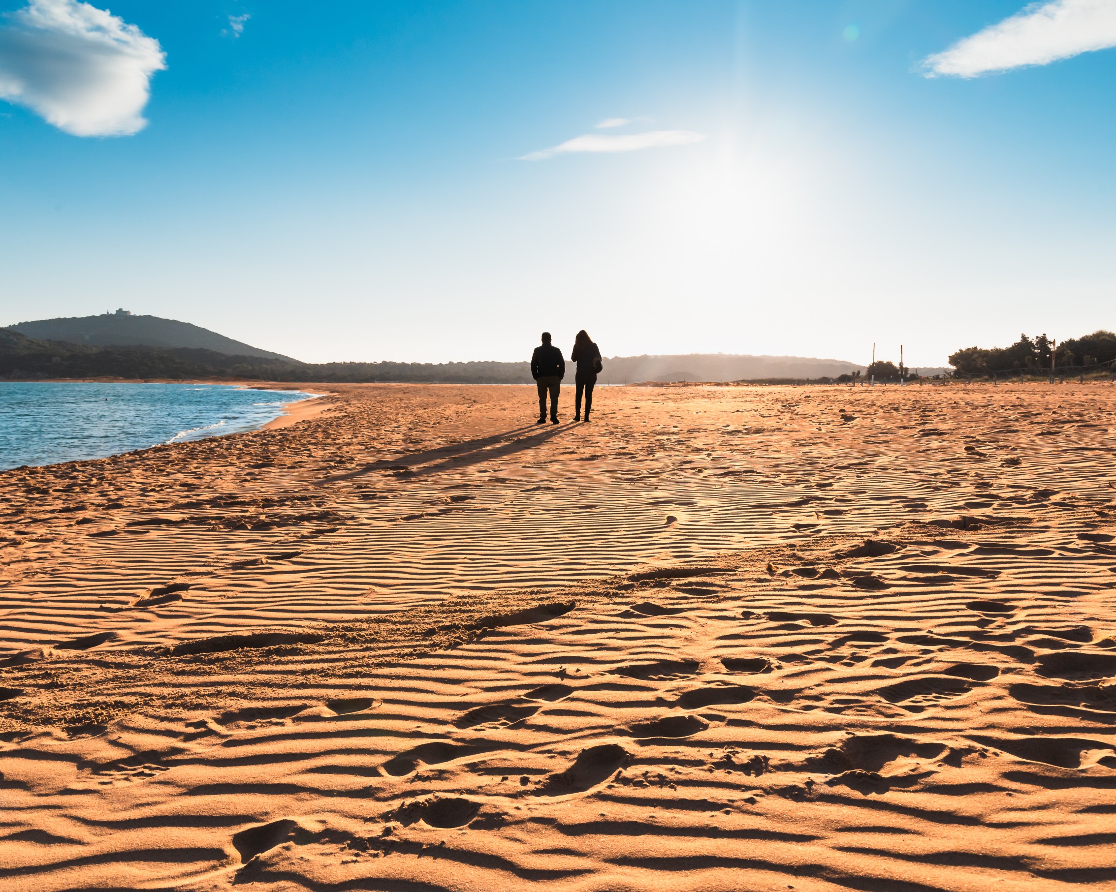 Couple walking on a Mediterranean beach at sunset for a Valentine’s Day getaway