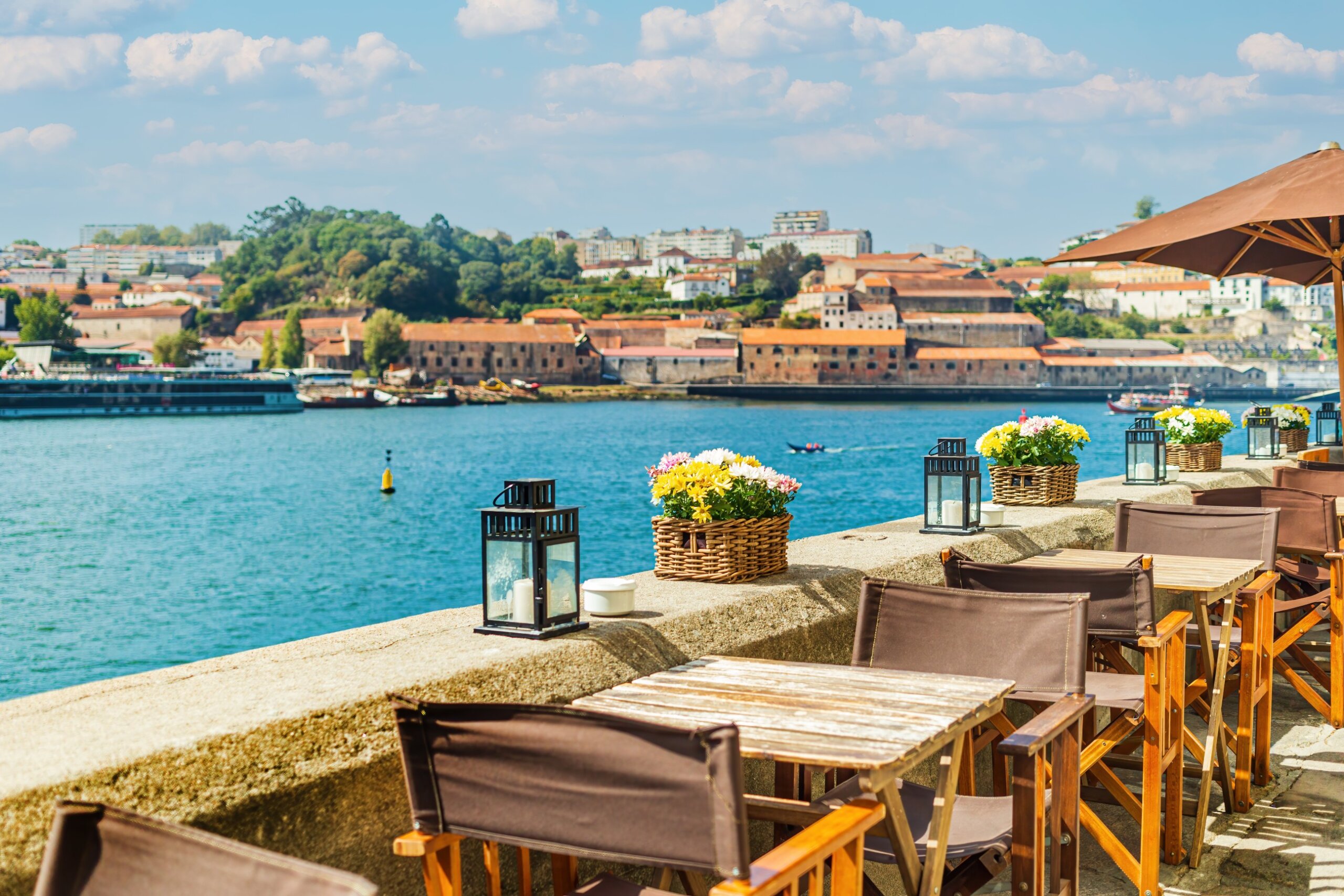 View of open-air street cafe on the banks of the River Douro in Porto, Portugal
