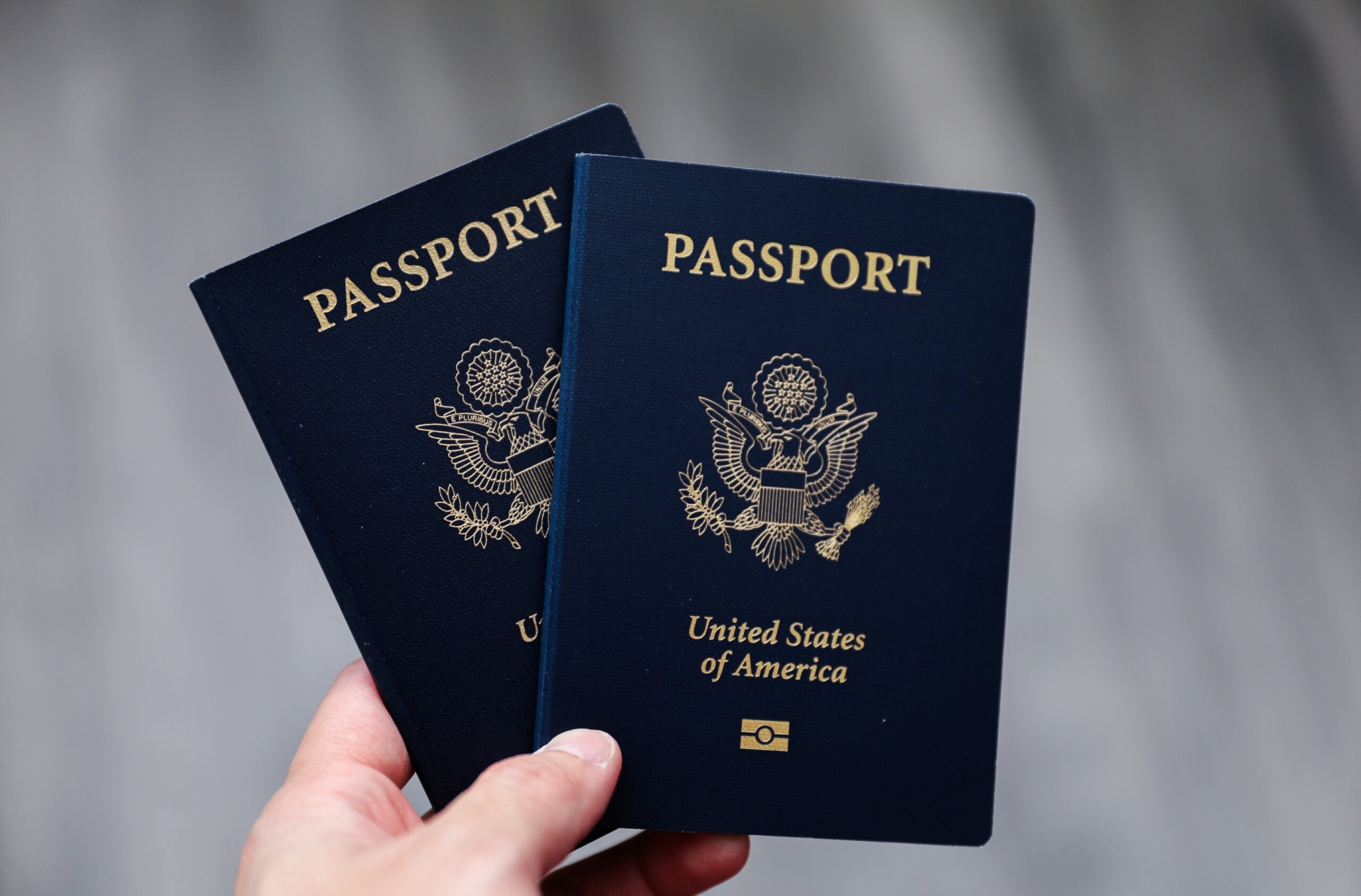 U.S. passport on a dark background, symbolizing travel, identity, citizenship, and international journeys, with patriotic colors and security features
