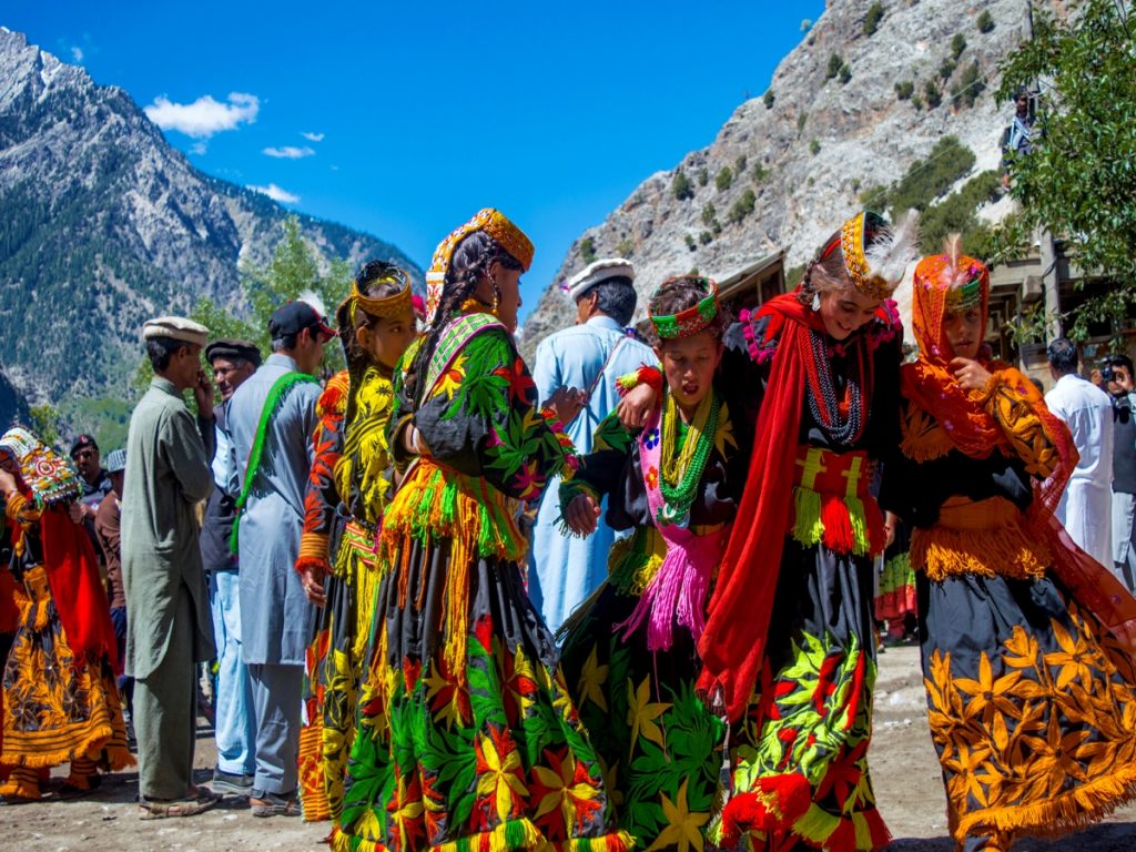 Kalash people dressed in colorful traditional clothing celebrating the winter solstice festival in the mountains of Pakistan.