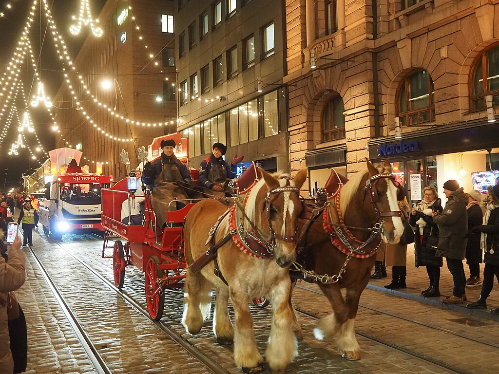 A horse-drawn carriage by the Finnish brewery Sinebrychoff (also known as Koff) at the St. Lucia's Day parade on the street Aleksanterinkatu in central Helsinki, Finland on an evening in December 2024.