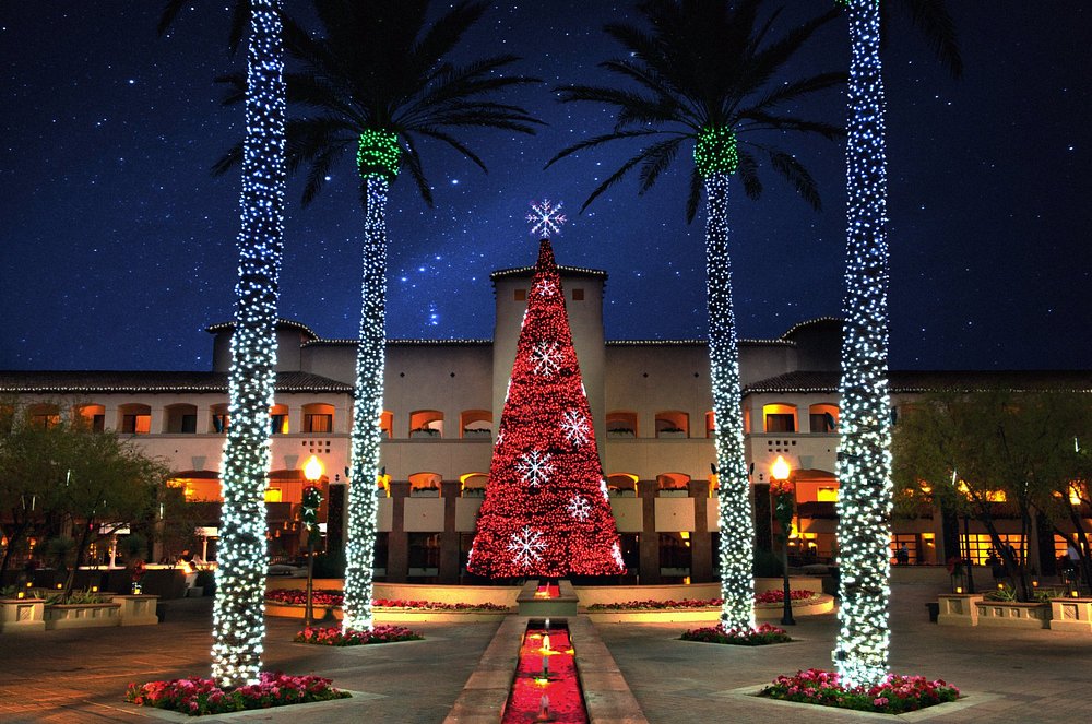 Hotel courtyard decorated with a large Christmas tree and illuminated palm trees, representing the world’s best Christmas hotels.