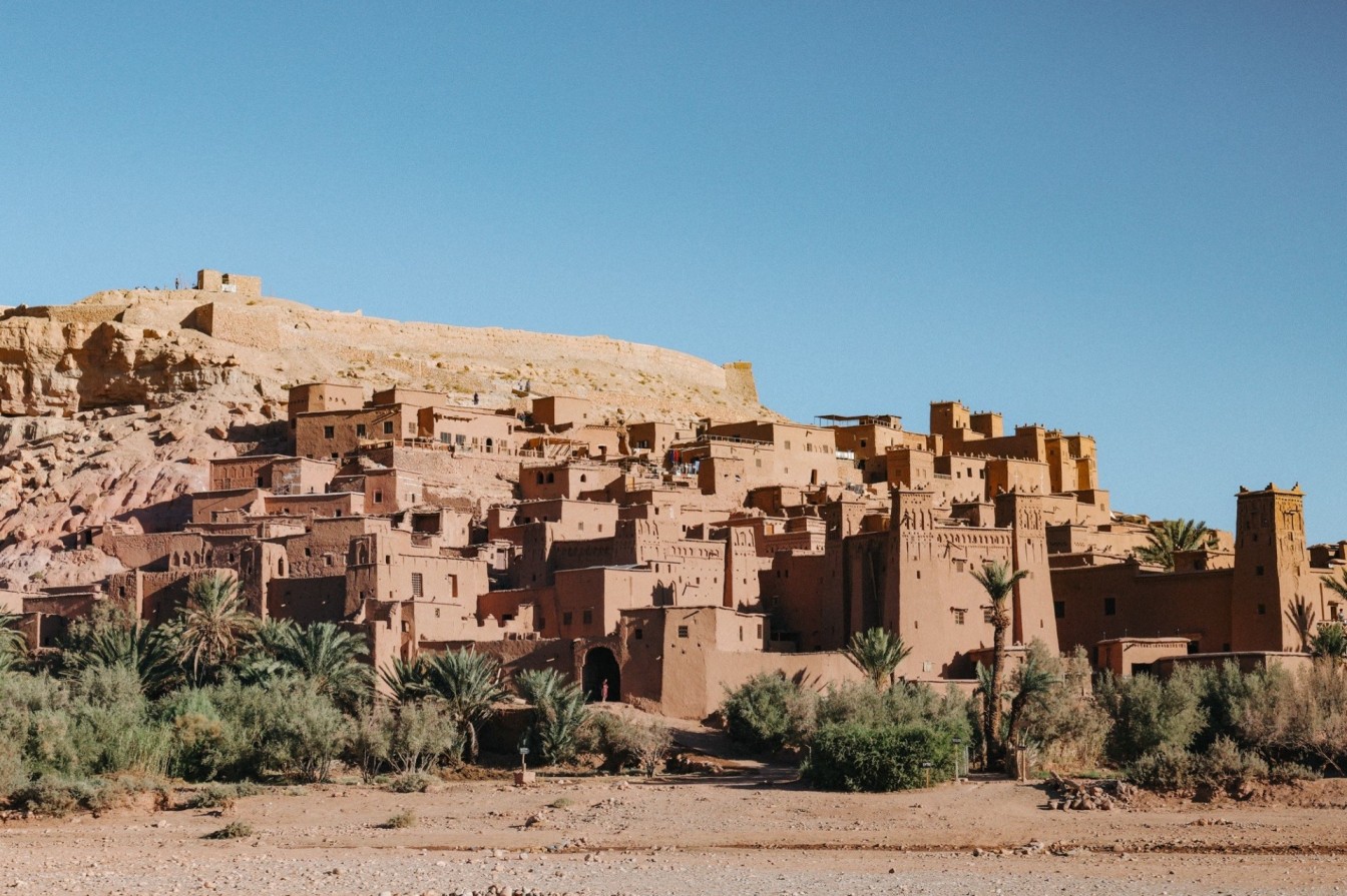 Ait Ben Haddou desert village in Morocco with clay buildings and a hillside backdrop.