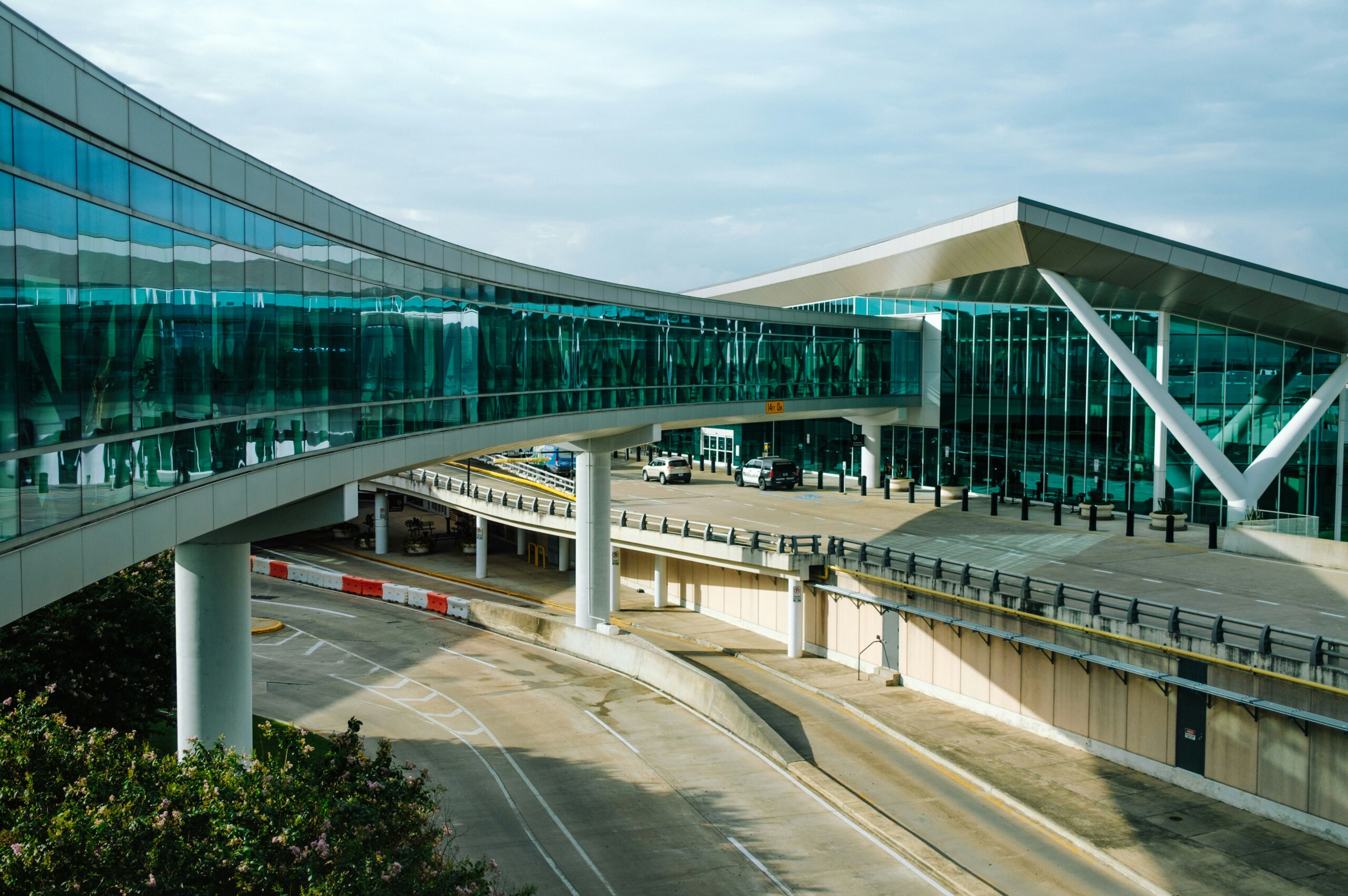 Modern glass airport walkway at a North American terminal representing the region’s most and least affordable airports.