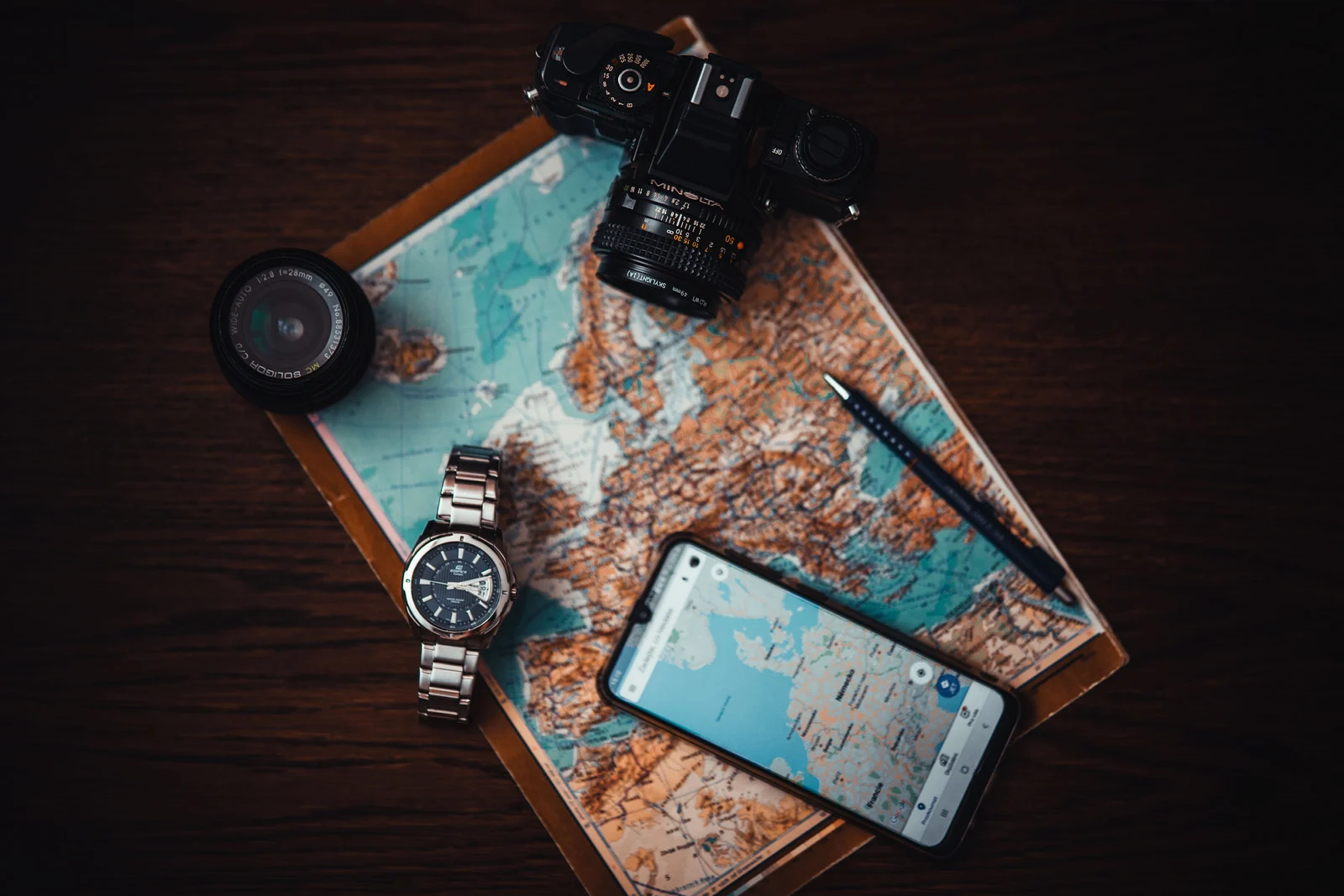 Smartphone on a world map representing the best travel apps for 2026 for trip planning, navigation, and travel organization