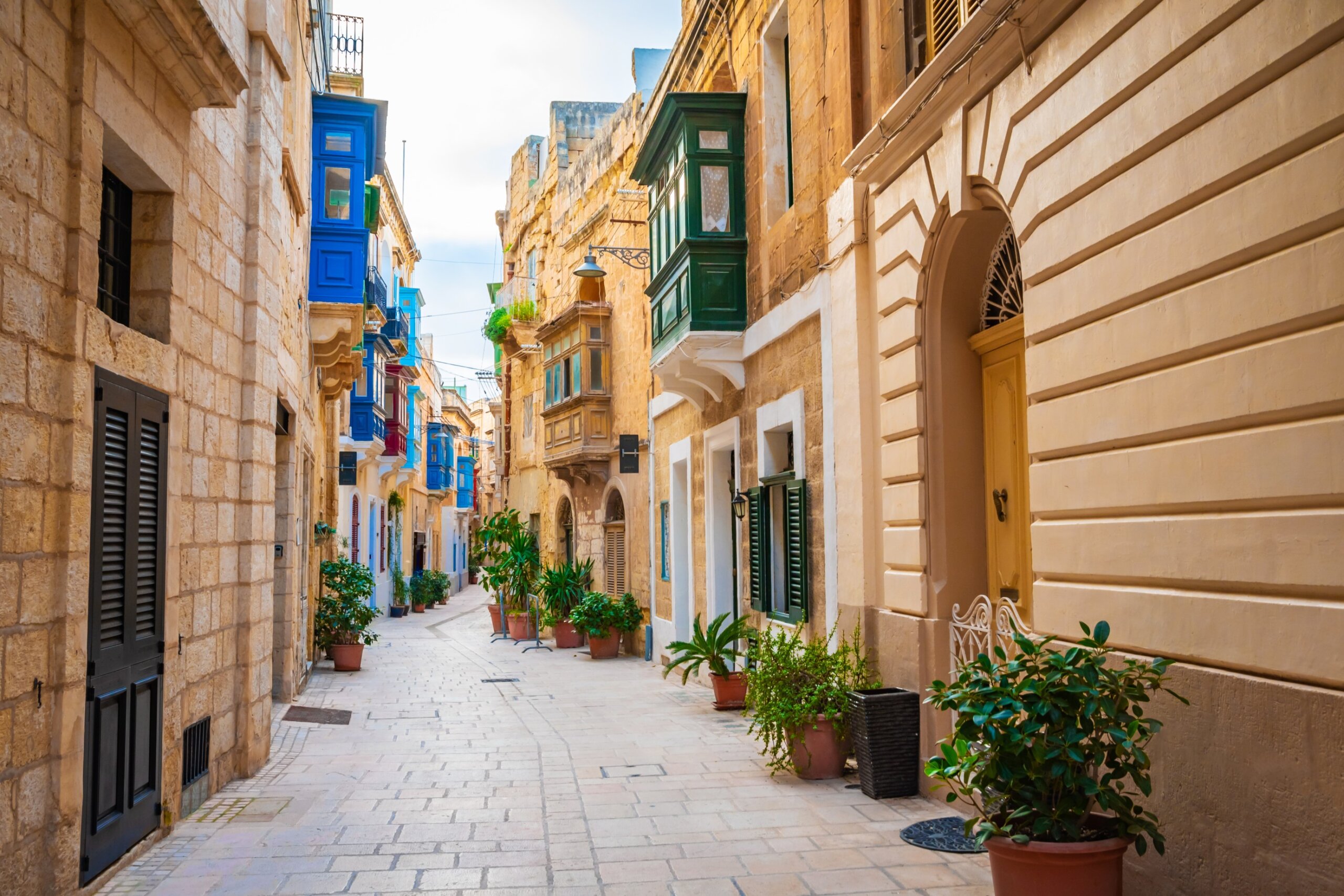 Cozy street and traditional colorful wooden balconies in Birgu, Malta