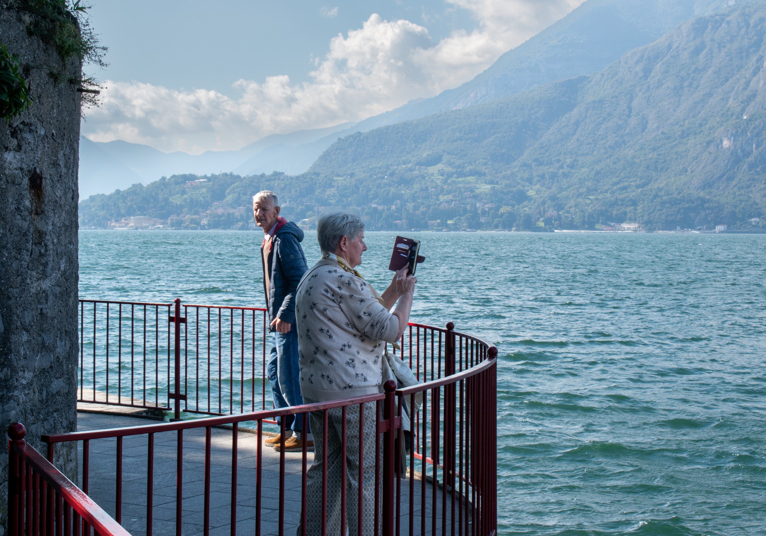 Senior Couple Taking Photos of Lake Como Panorama in Varenna, Italy, During Off-Season