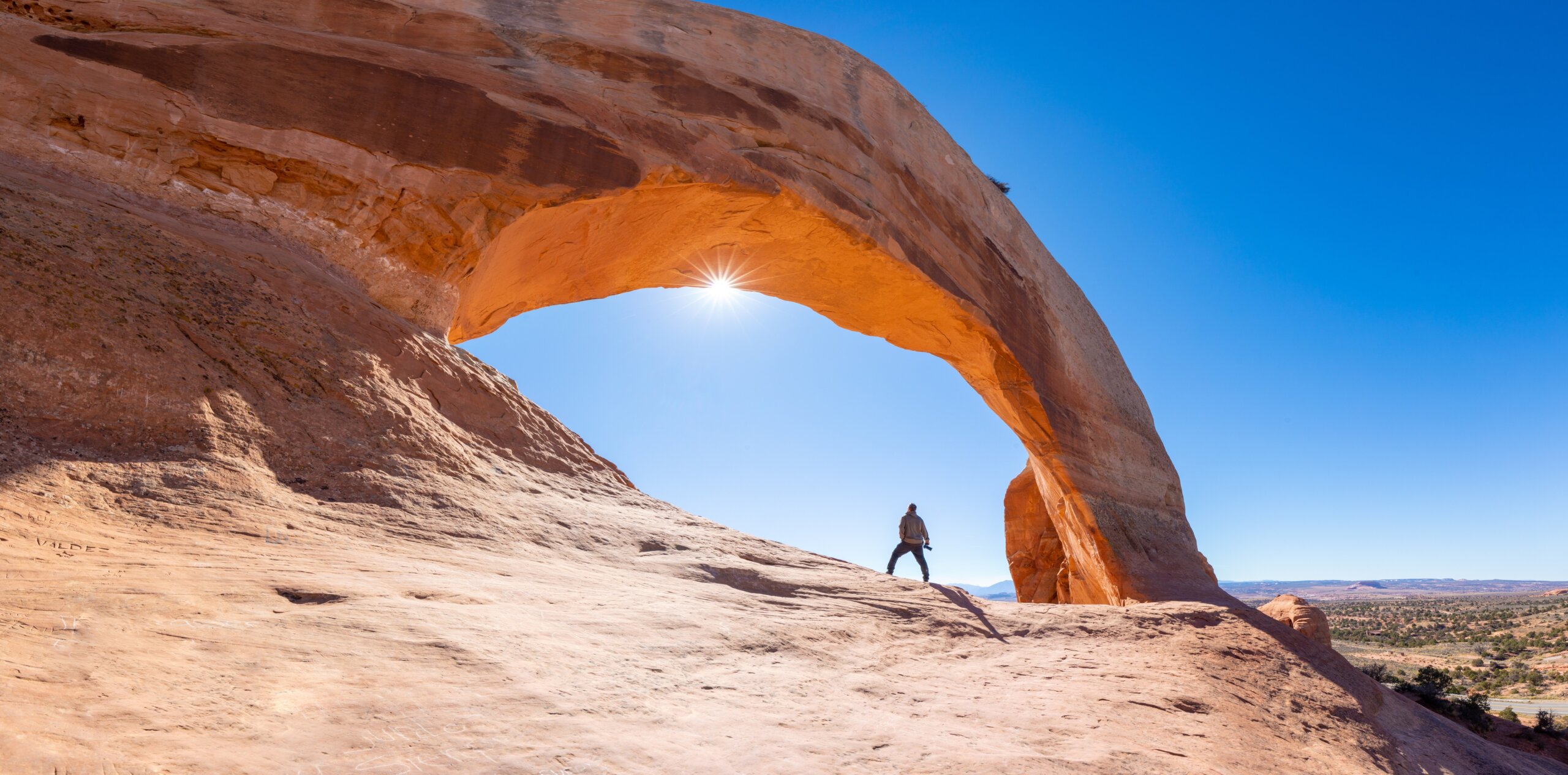 Wilson Arch is a natural sandstone arch in southeastern Utah, United States, just off U.S. Route 191 in San Juan County. It is located near the town of Page. Summer day with blue skies.