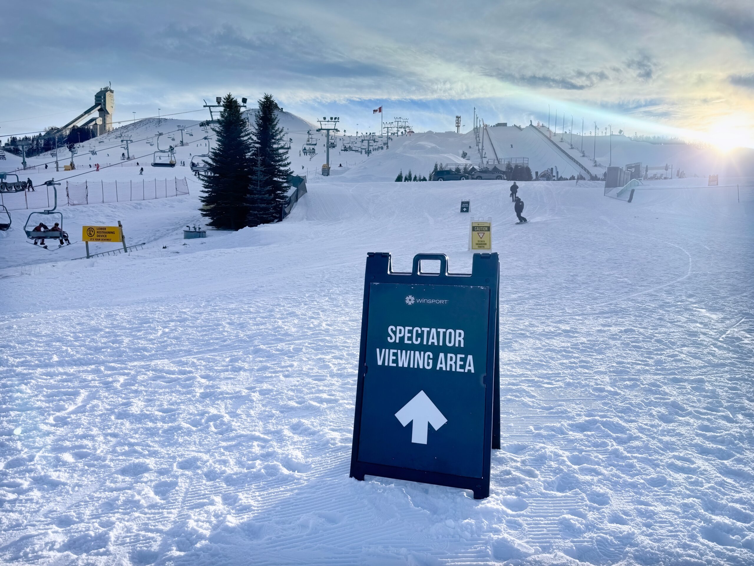 Calgary, Alberta, Canada. Jan 10, 2026. A spectator viewing area sign stands at WinSport Canada Olympic Park during a sunny winter day.