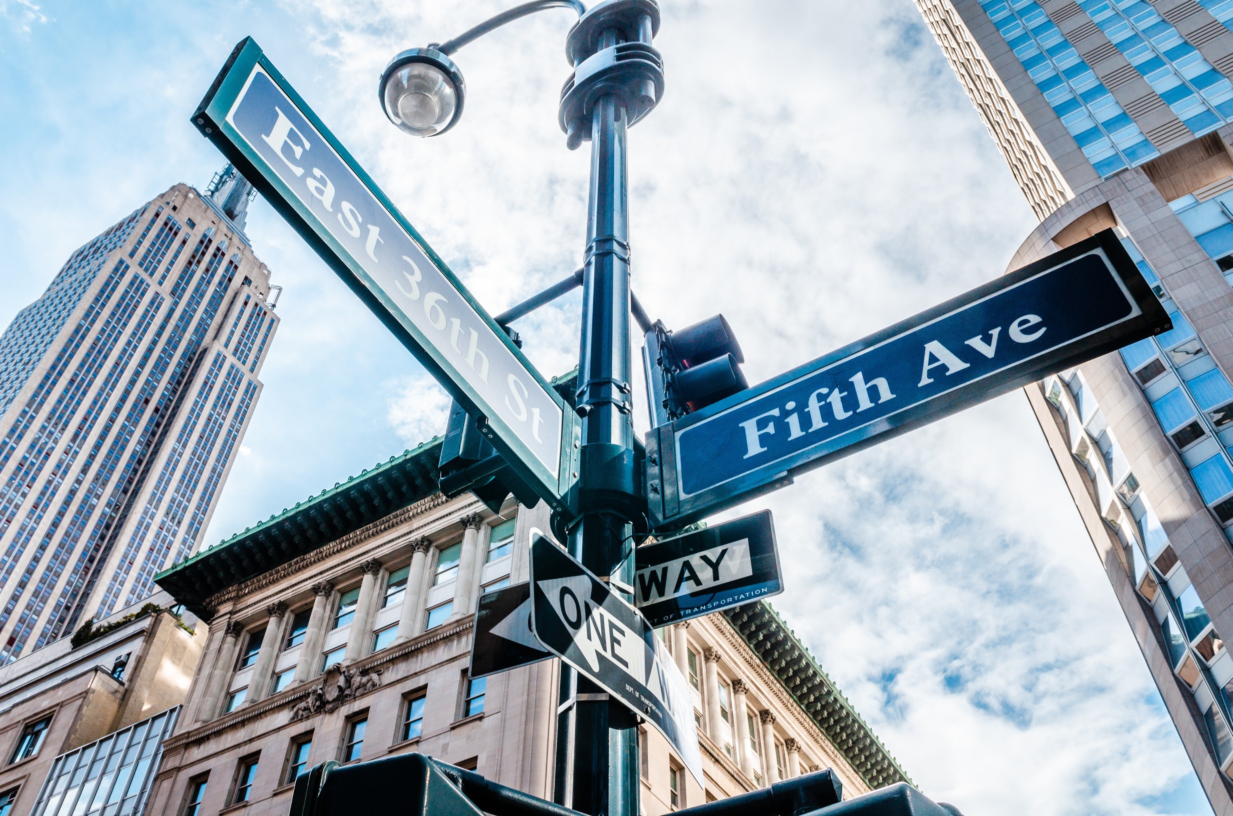 Fifth Avenue sign New York City (5th Ave sign NYC) low angle view with skyscraper
