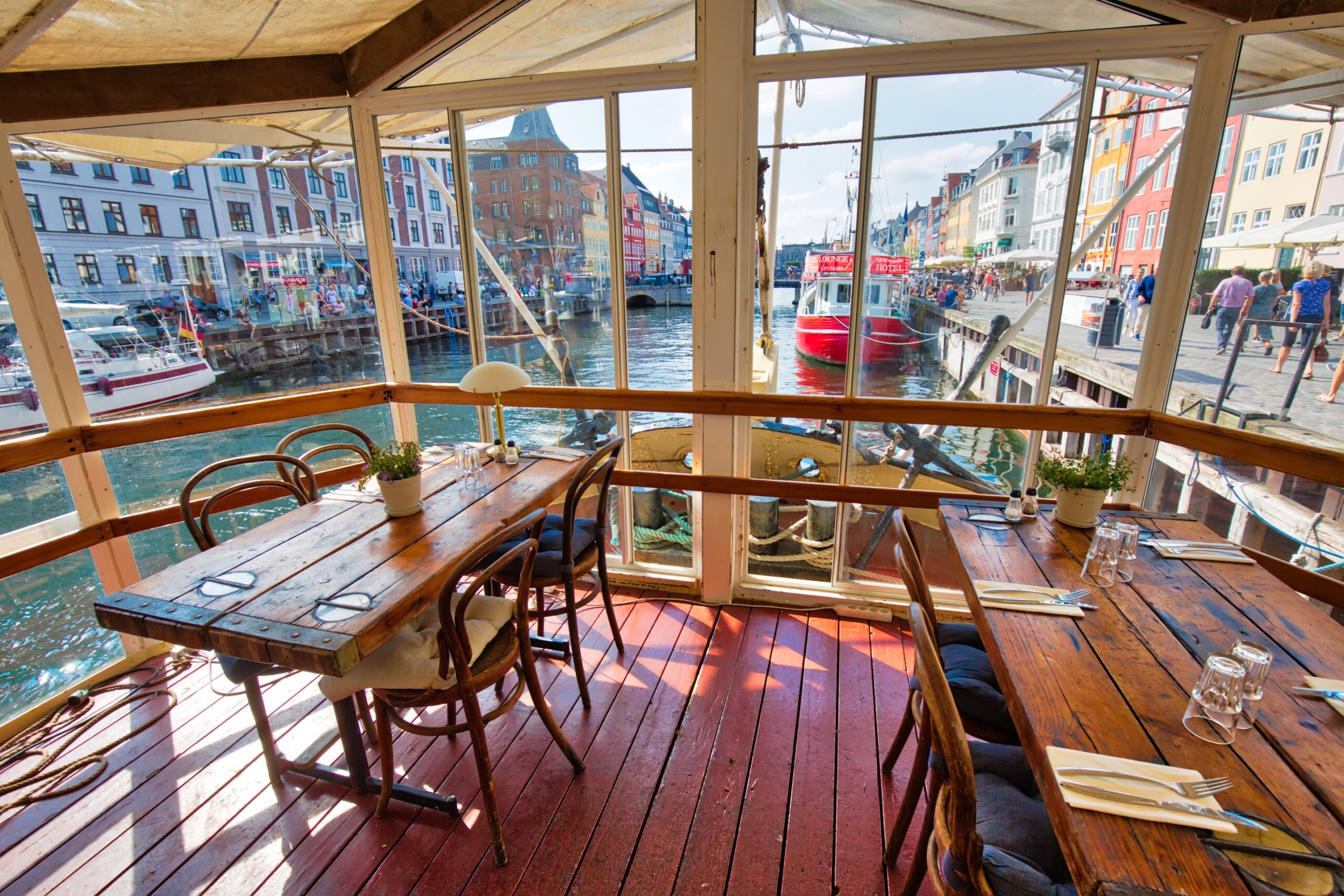 European waterfront café with canal view and wooden tables
