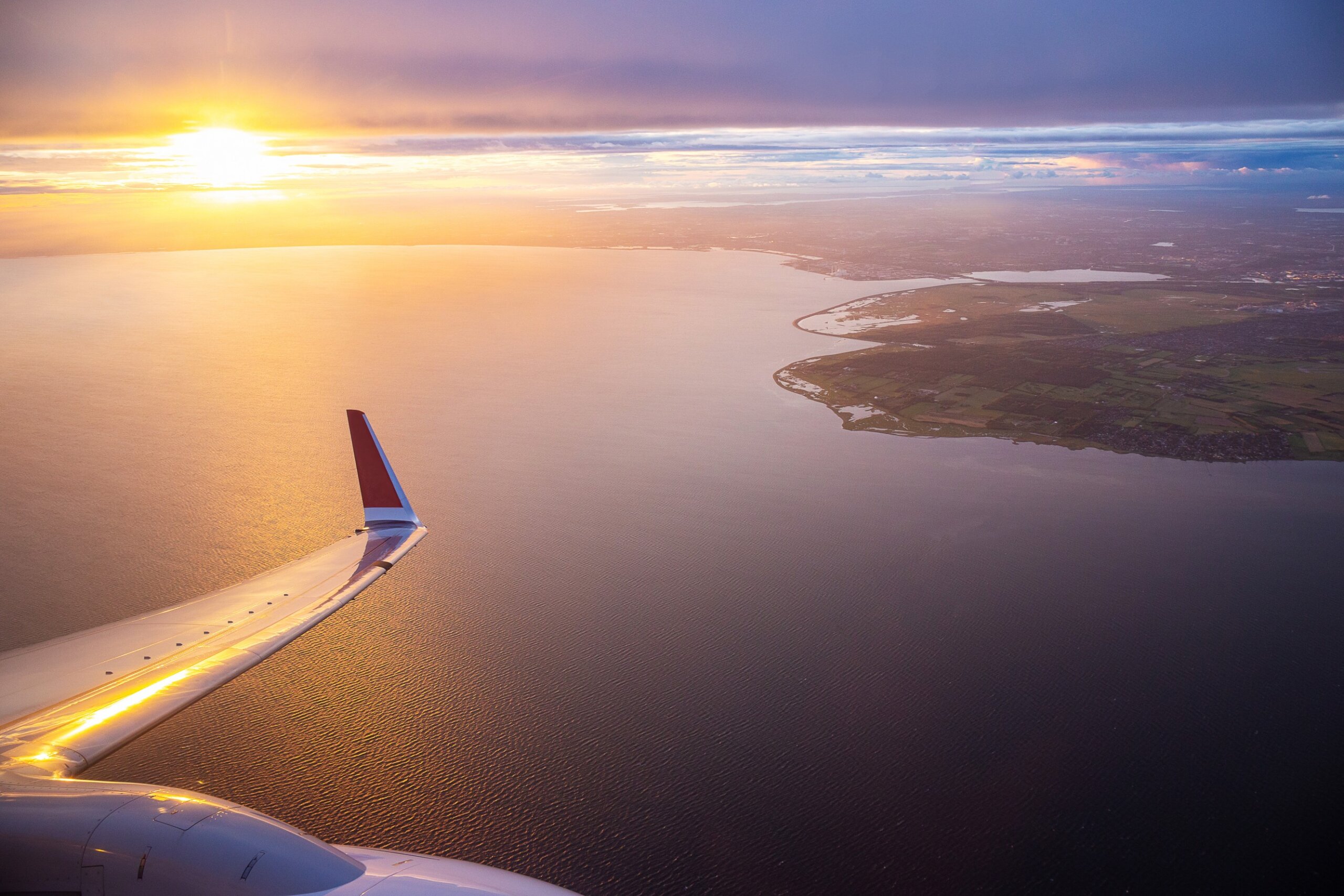 Sunset sky on airplane window over Copenhagen, Denmark in Friday evening flight