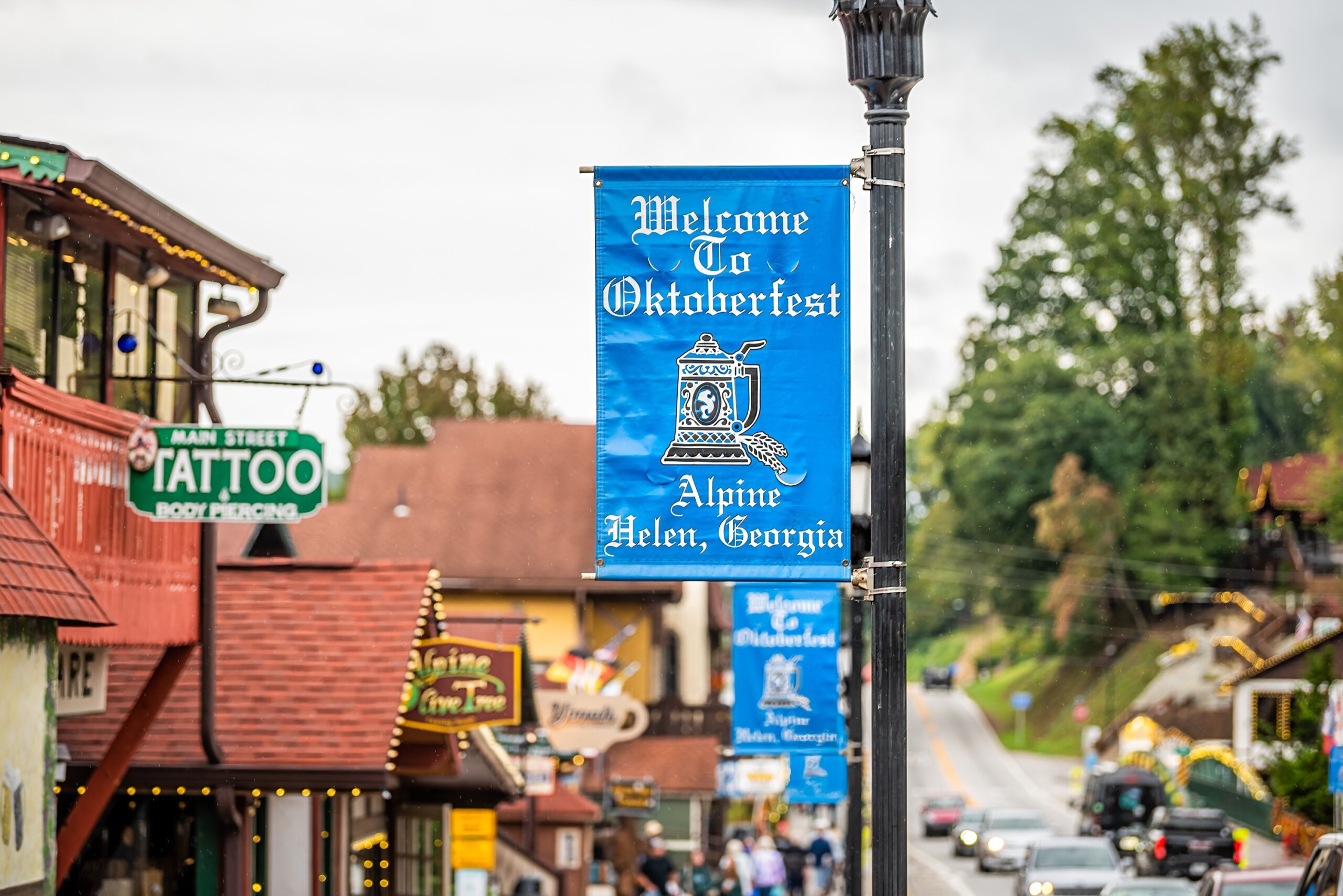 Helen, USA - October 5, 2021: Helen, Georgia Bavarian village stores shops with banner closeup for welcome to Oktoberfest festival on main street by historic architecture buildings