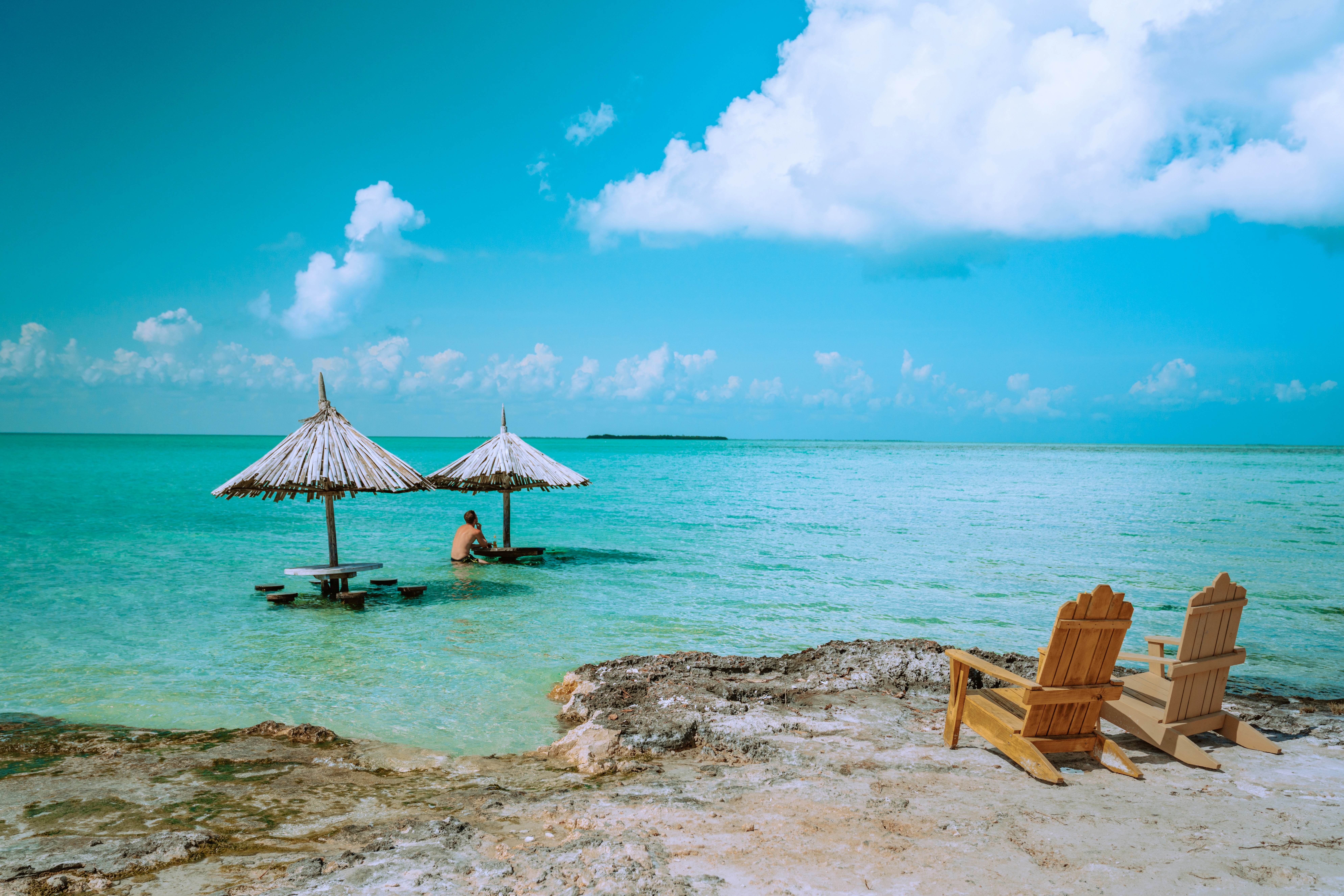 Belize beach with turquoise Caribbean water and lounge chairs, featured in a Belize travel guide