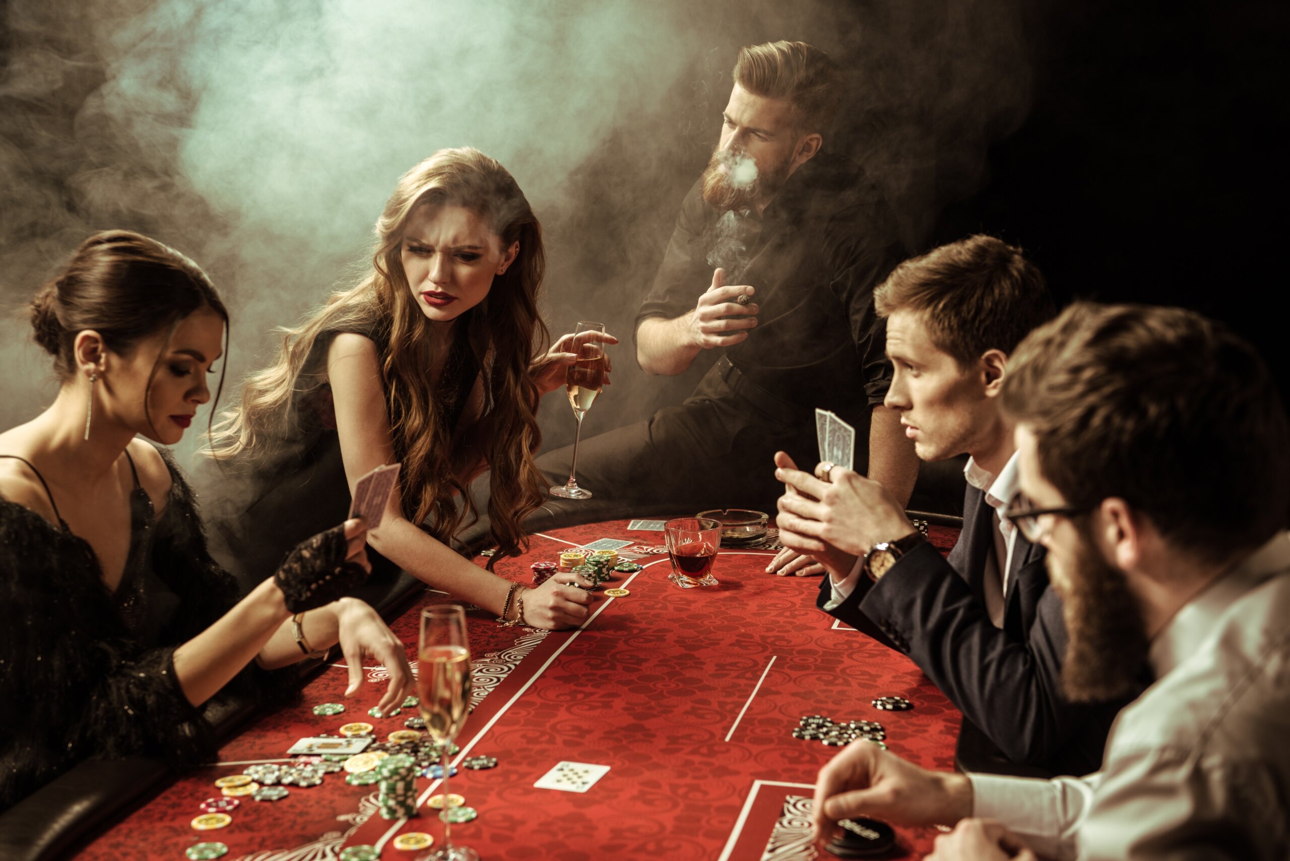 side view of people playing poker together in casino
