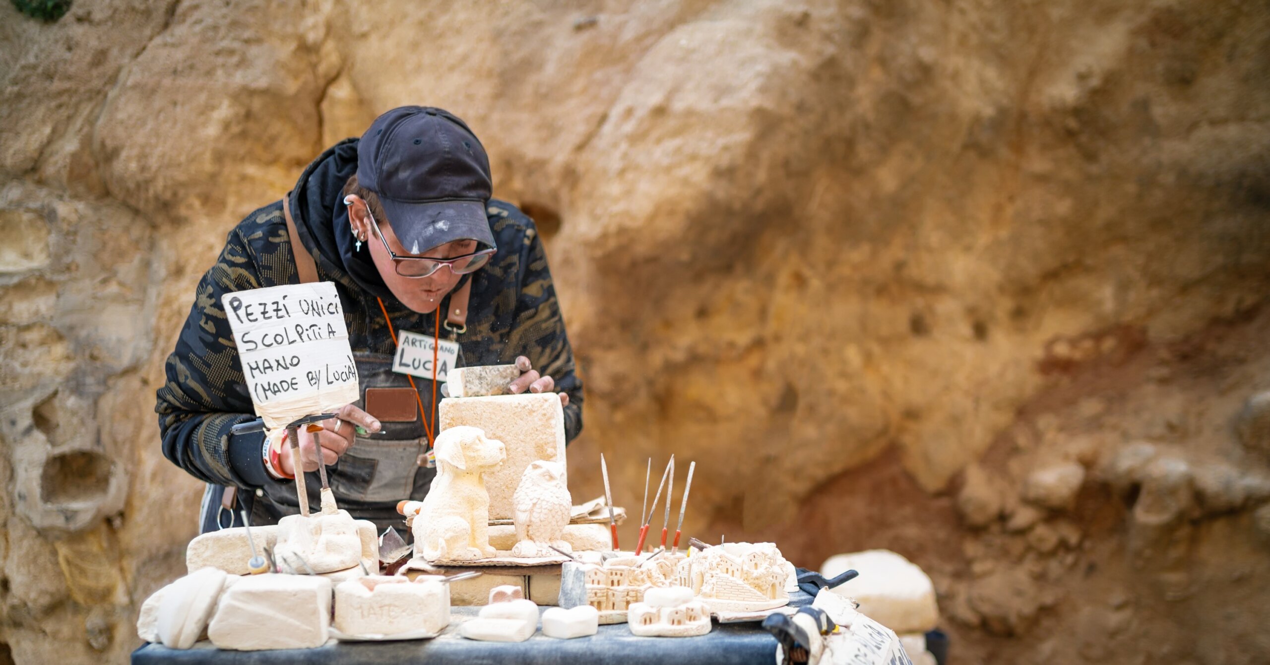 artisan woman working stone on street
