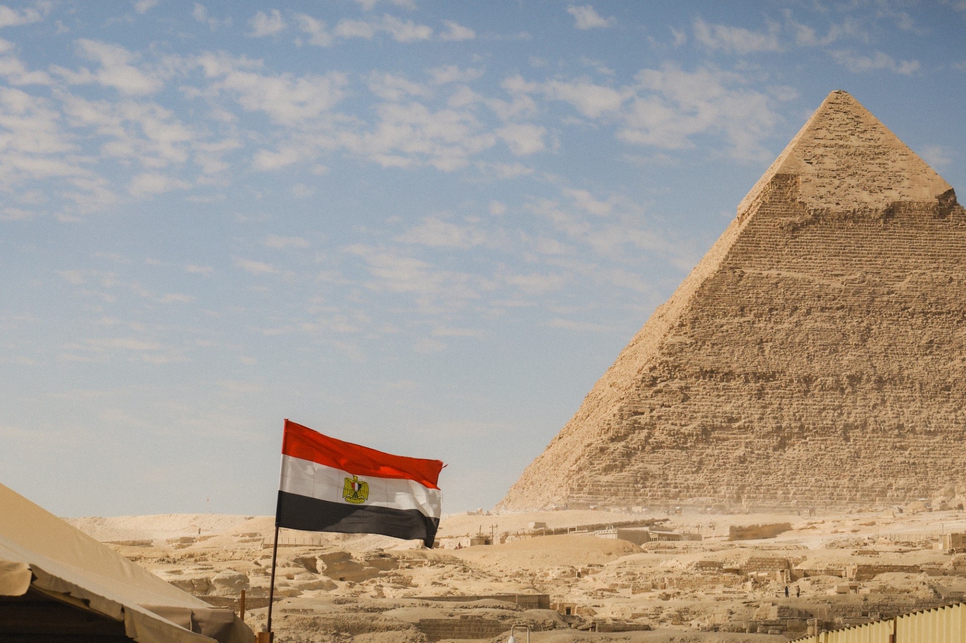Egyptian flag in front of the Pyramids of Giza showcasing ancient Egypt history