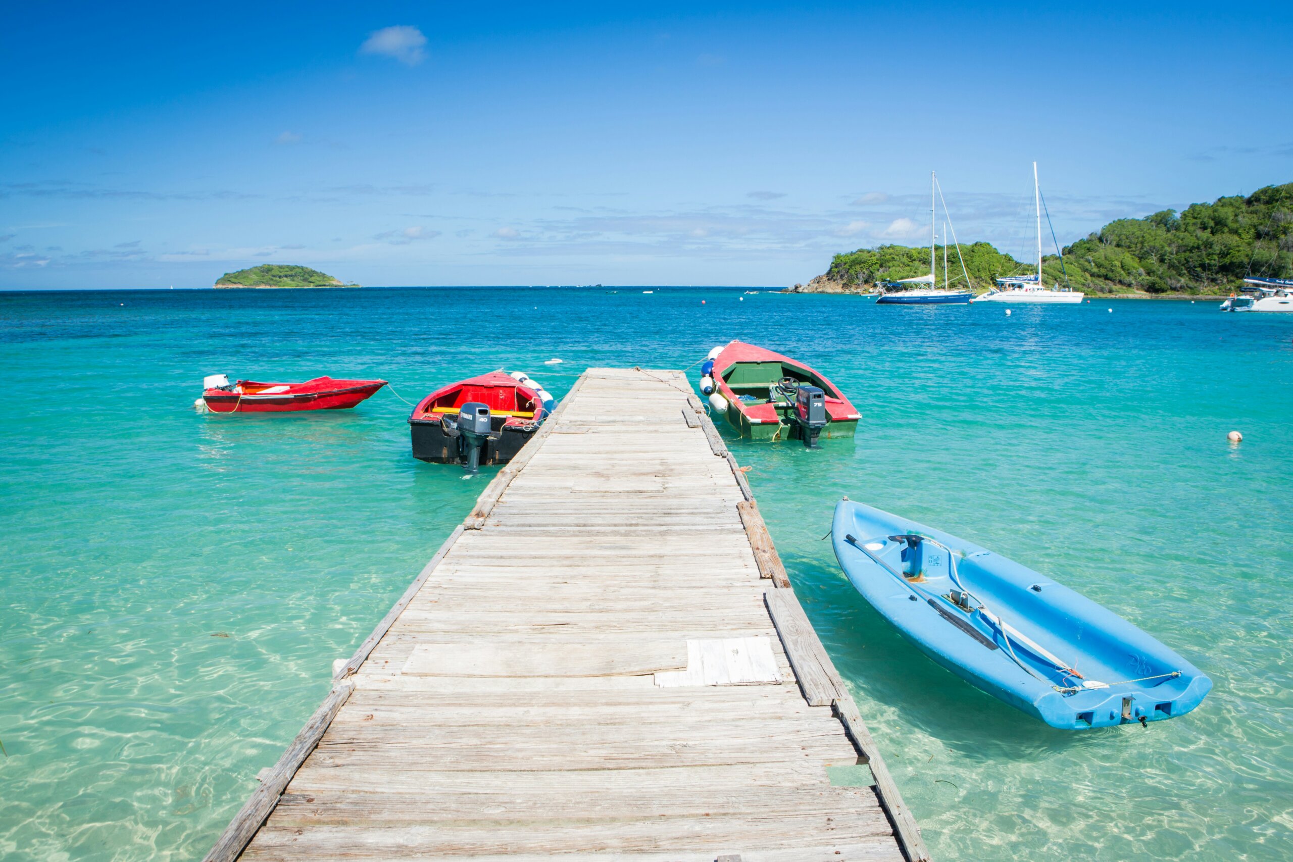 Wooden dock over turquoise water on one of the safest Caribbean islands to relax