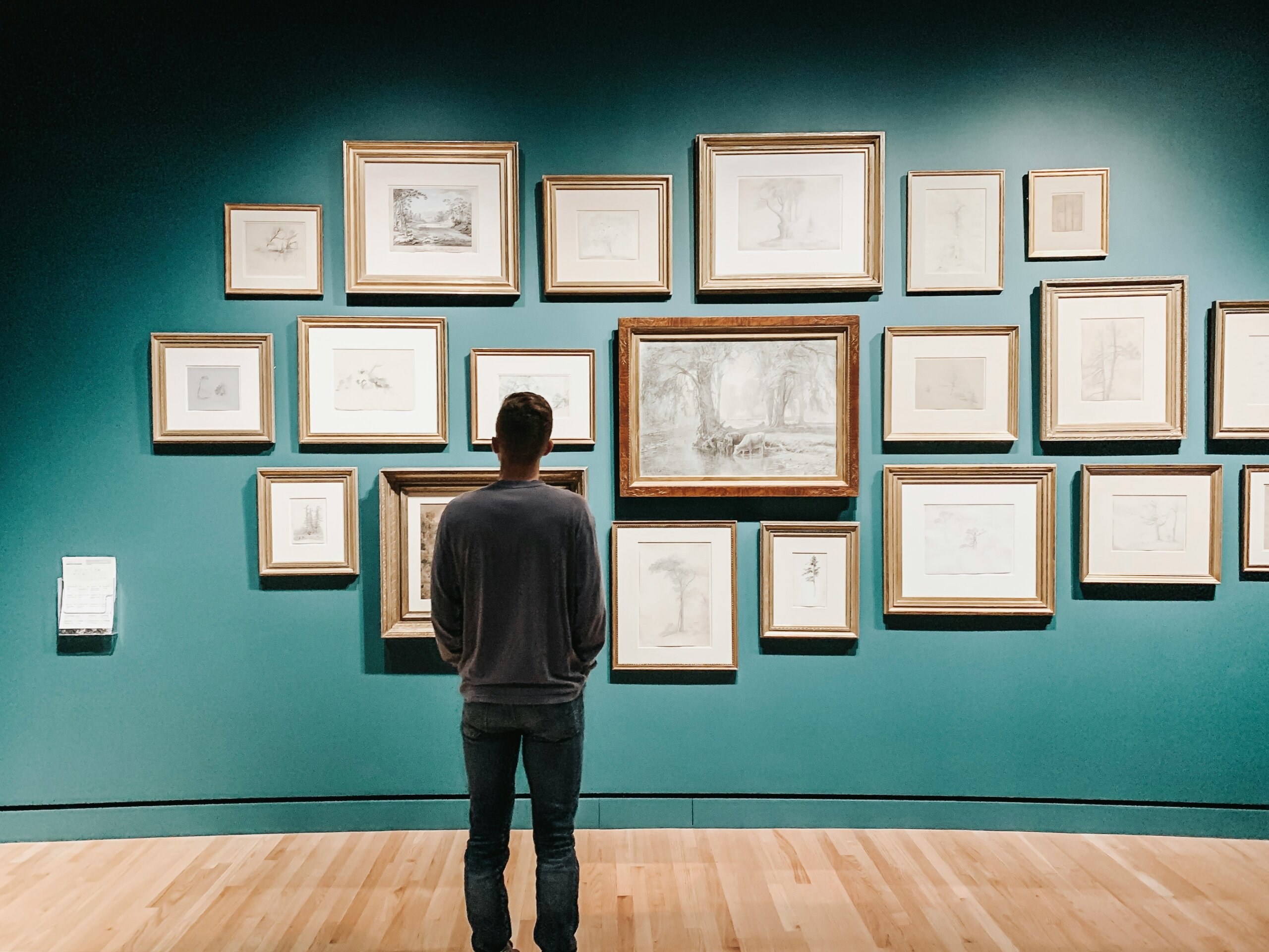Visitor viewing framed artwork in a museum gallery, symbolizing museums worth crossing oceans for