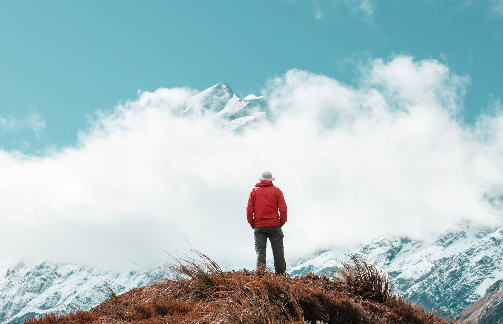 hiker overlooking snowy mountains on a soft adventure travel hike with big views