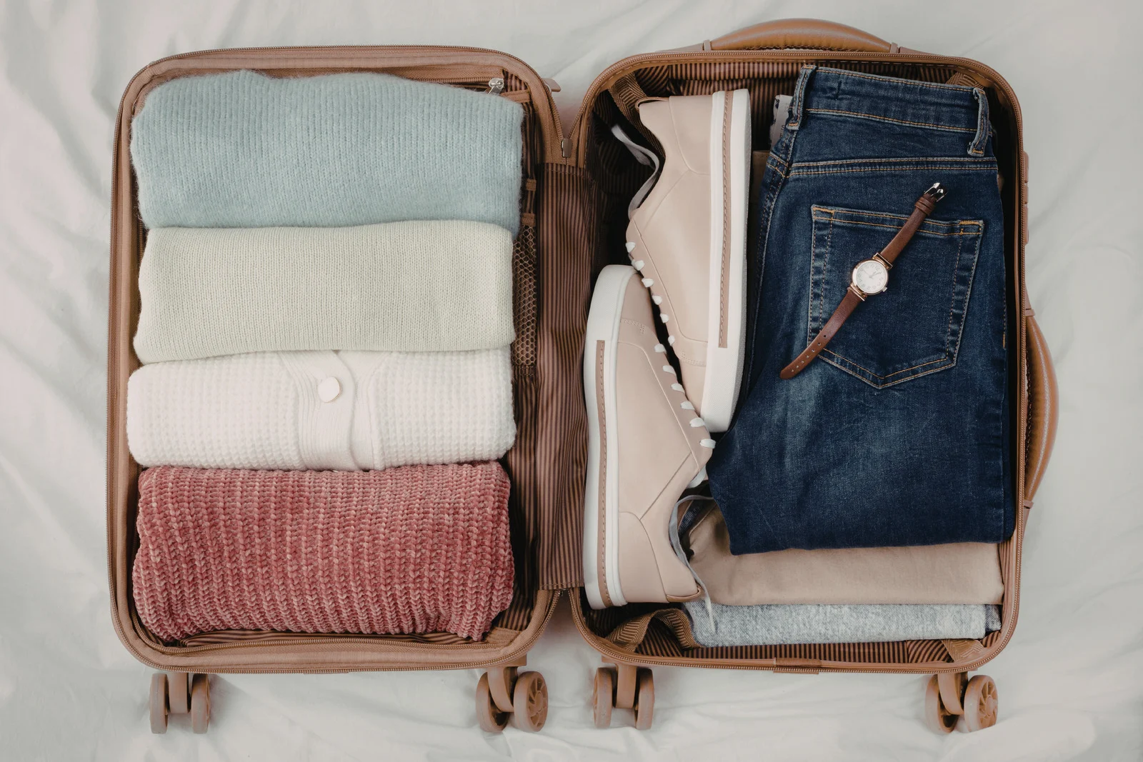 Open suitcase with folded clothes and sneakers showing smart packing tips for international travel and avoiding packing mistakes