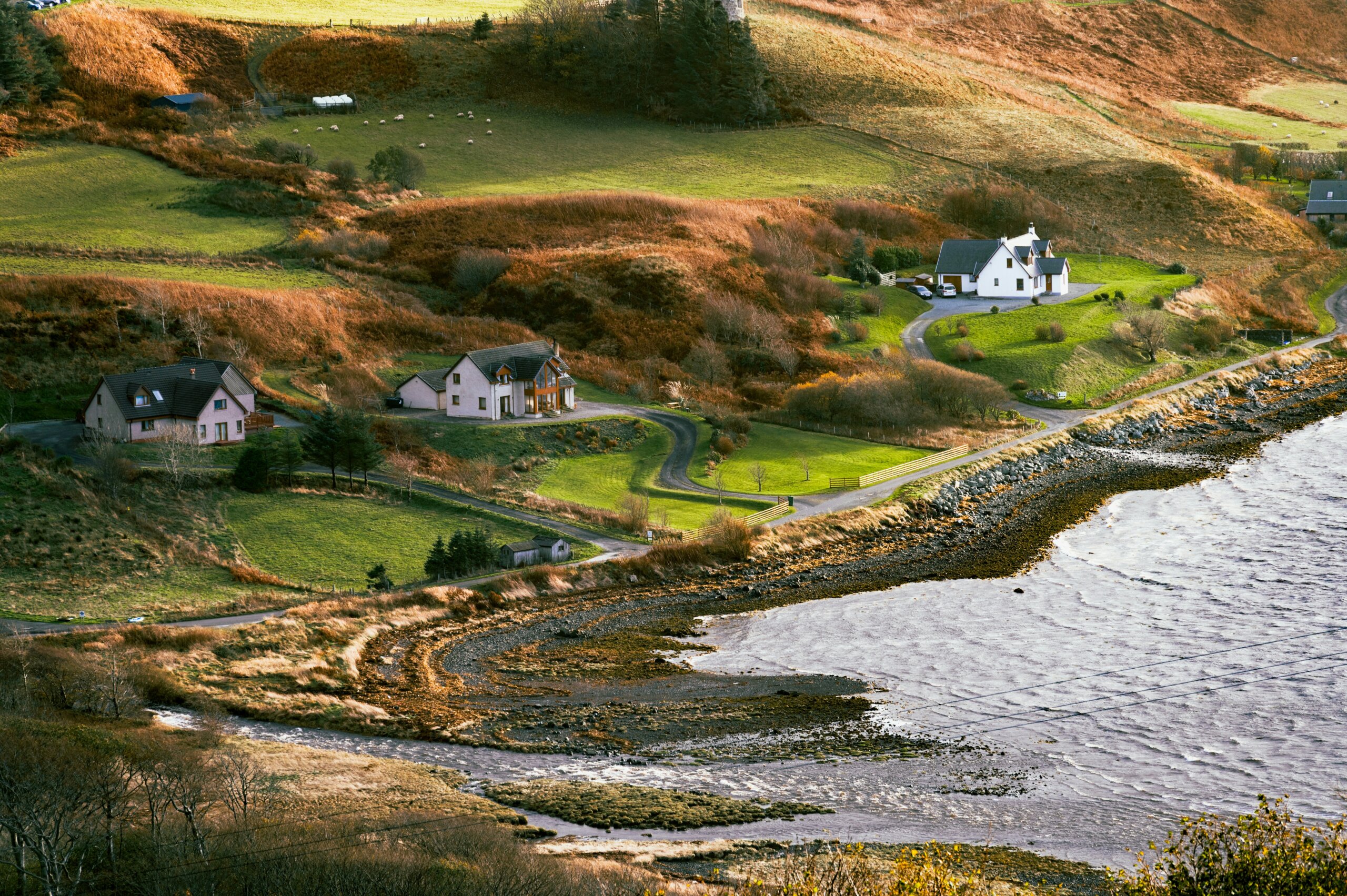 Coastal hillside homes and shoreline on the Isle of Skye, Scotland, featured image for an Isle of Skye itinerary