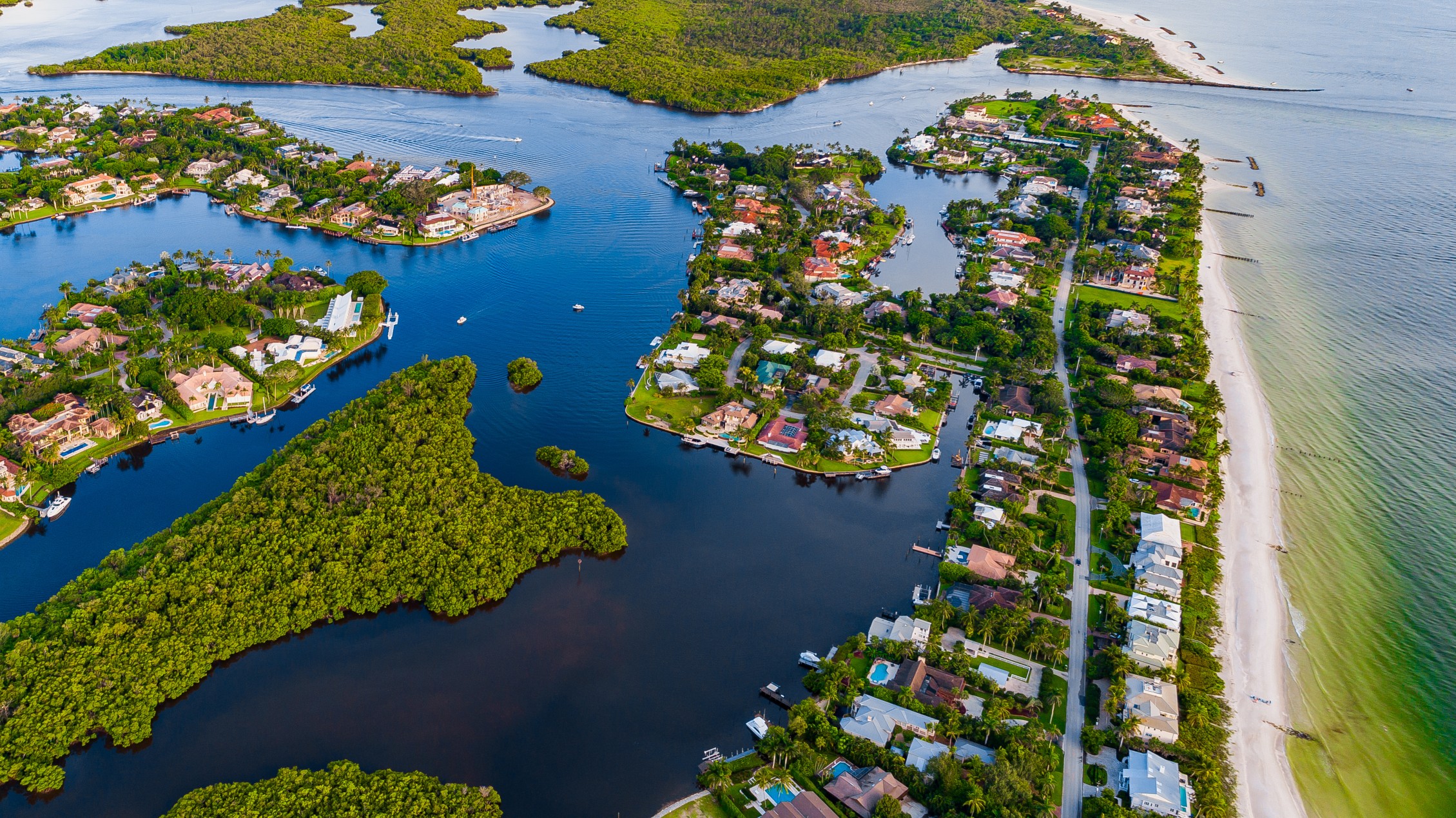 Aerial view of coastal homes, waterways, and beach in Florida