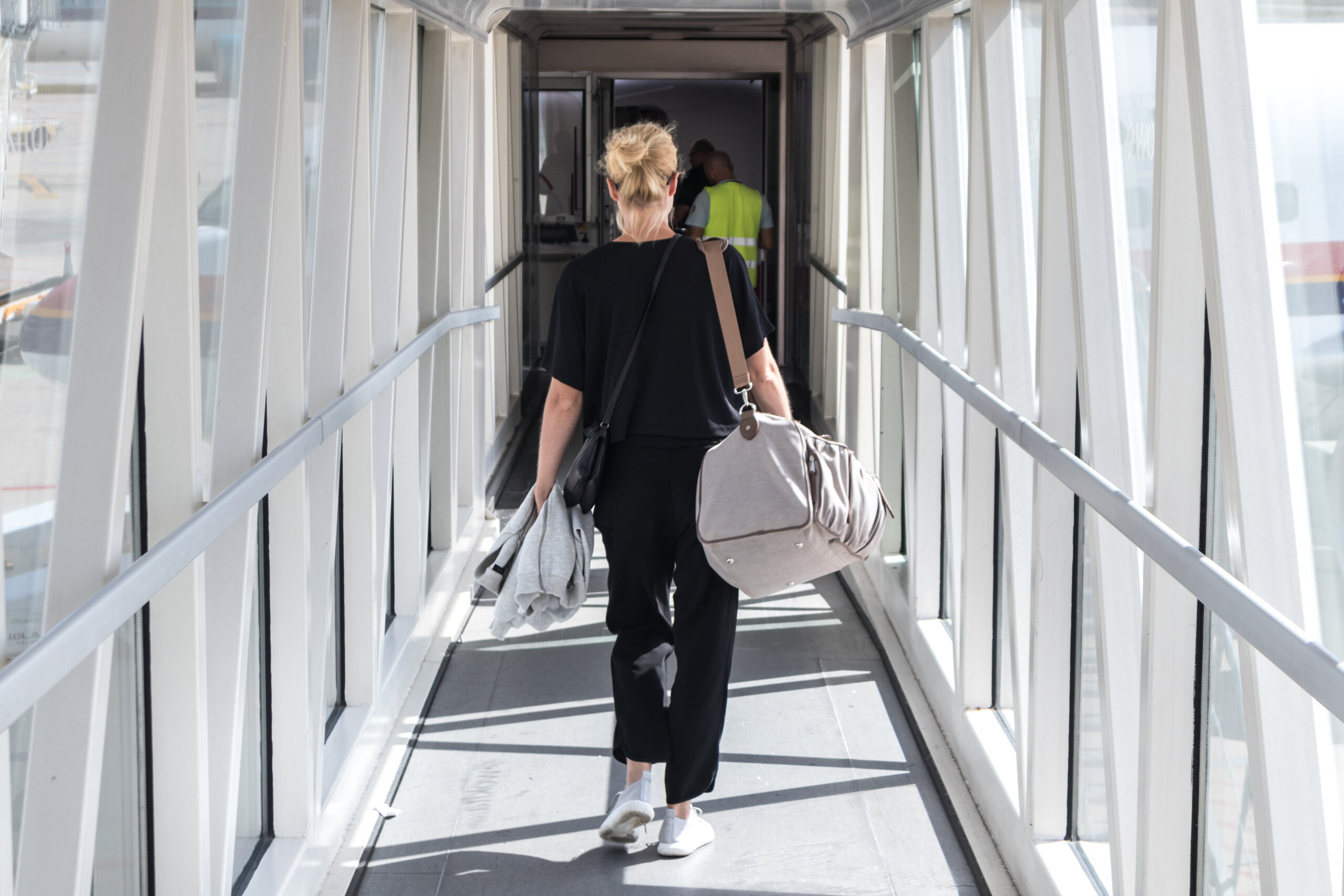 passenger boarding a plane through a jet bridge before takeoff