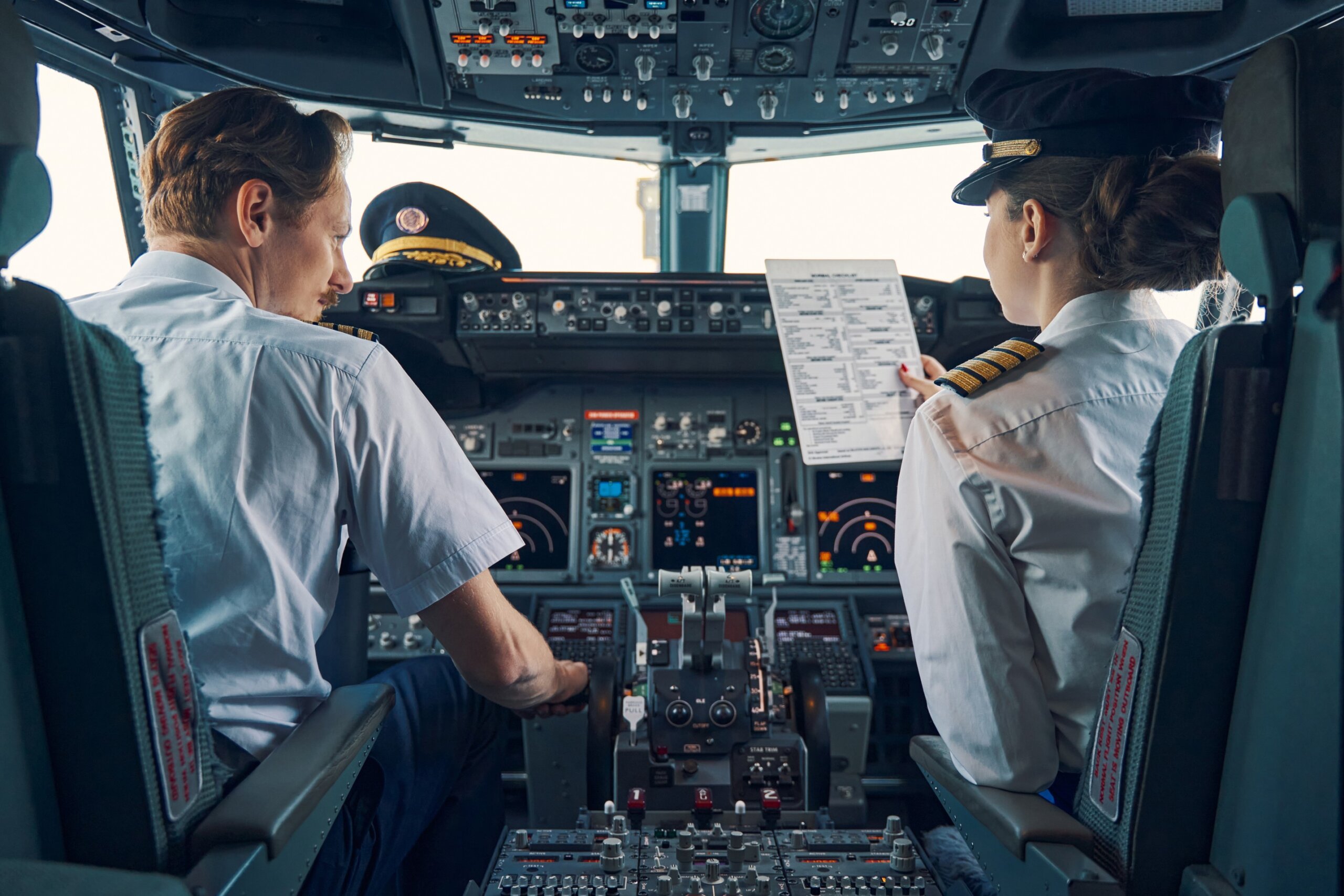 Pilot and female first officer seated in the flight deck
