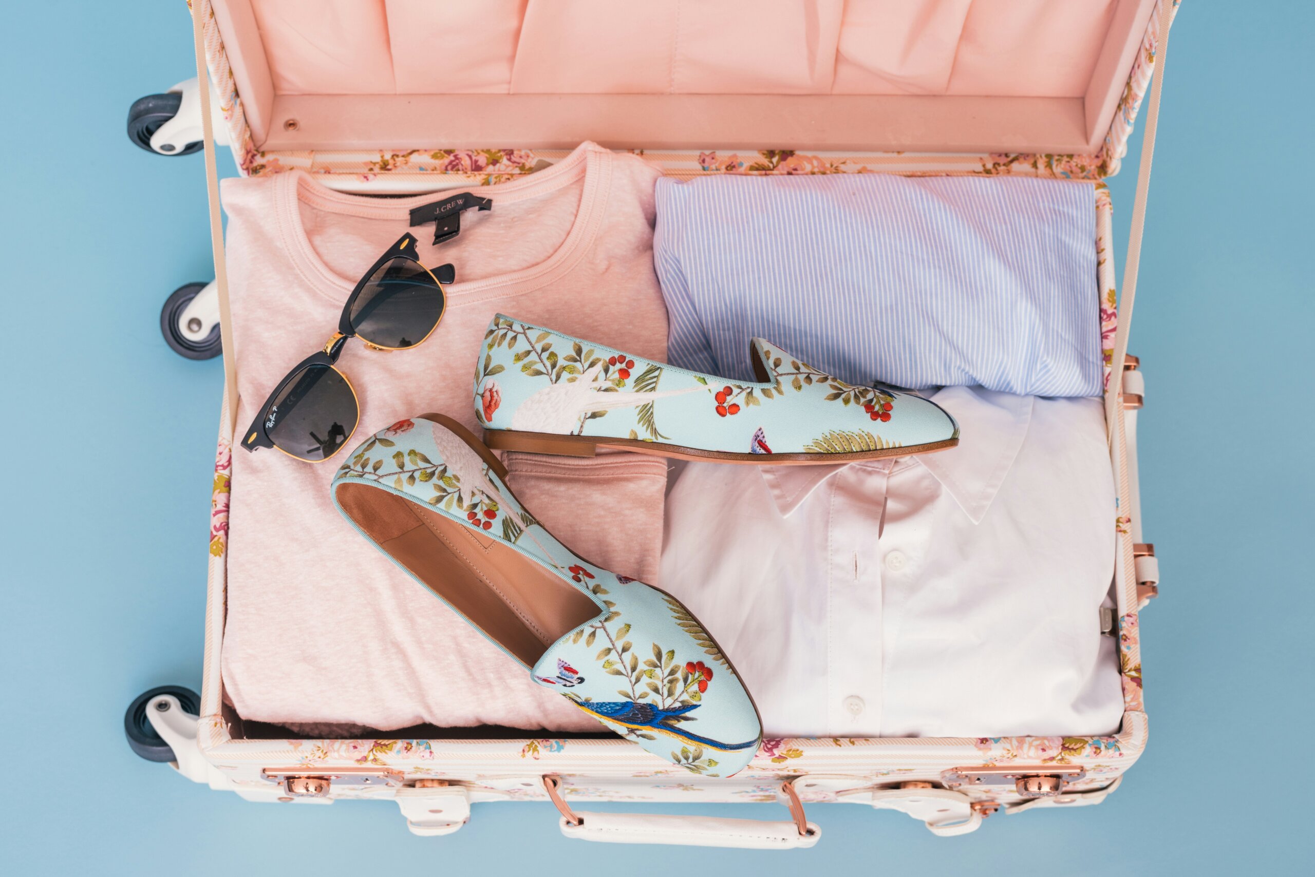 carry-on suitcase packed with clothes for a month of travel