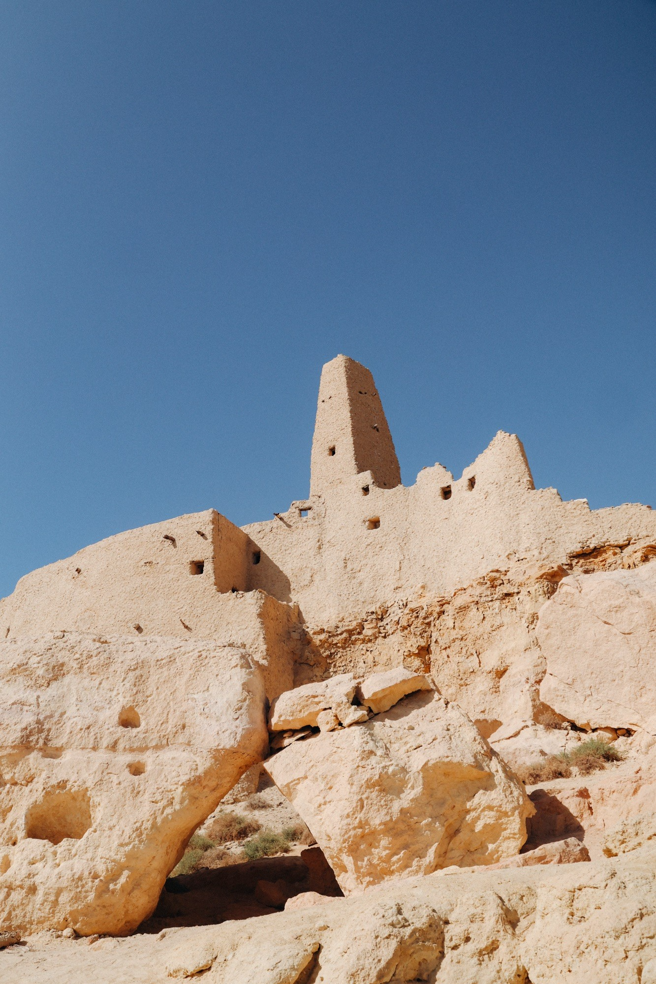 Ancient desert ruins and sandstone fortress in Egypt under a clear blue sky