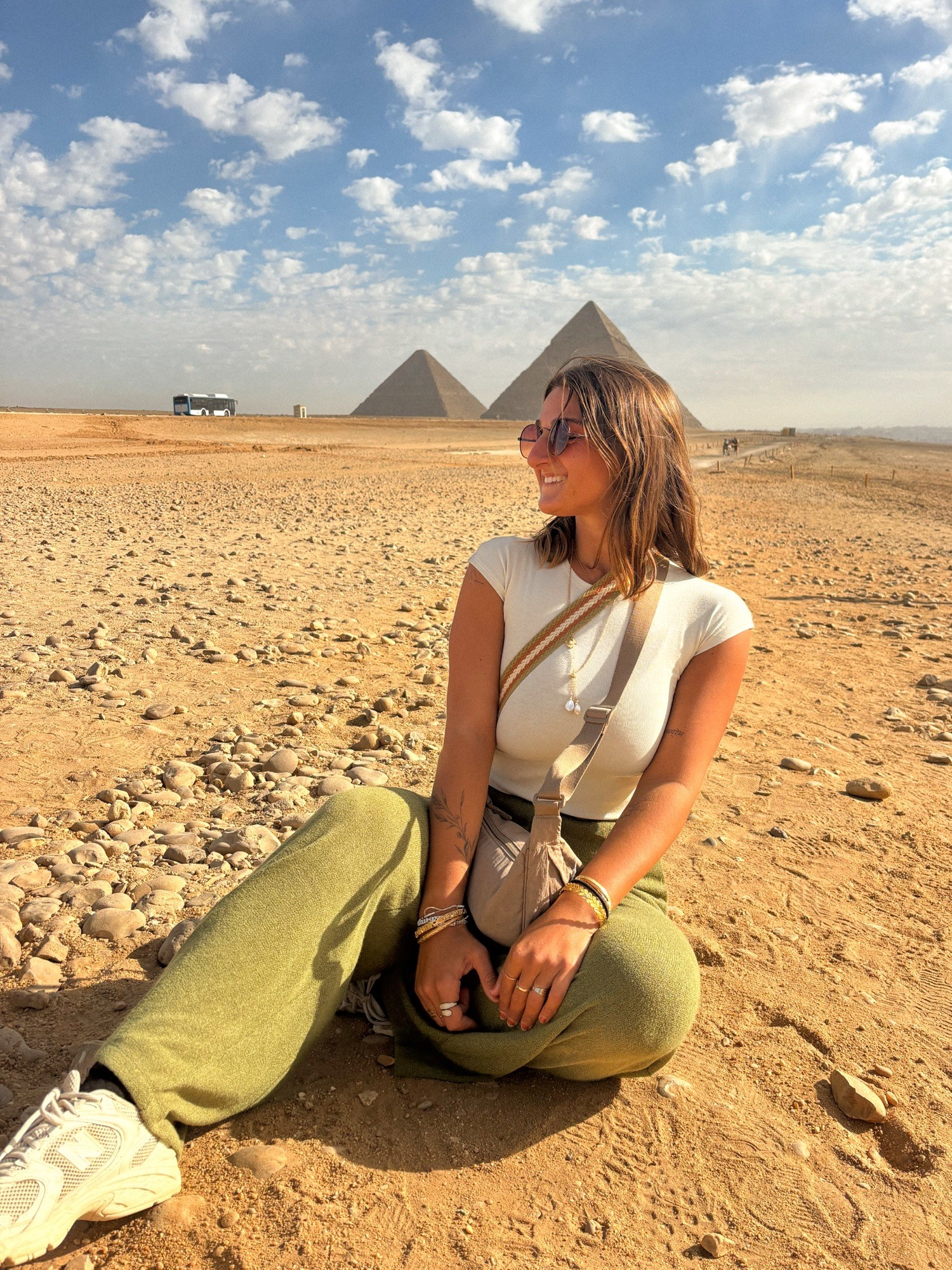 traveler sitting near pyramids of giza cairo one day itinerary desert egypt travel