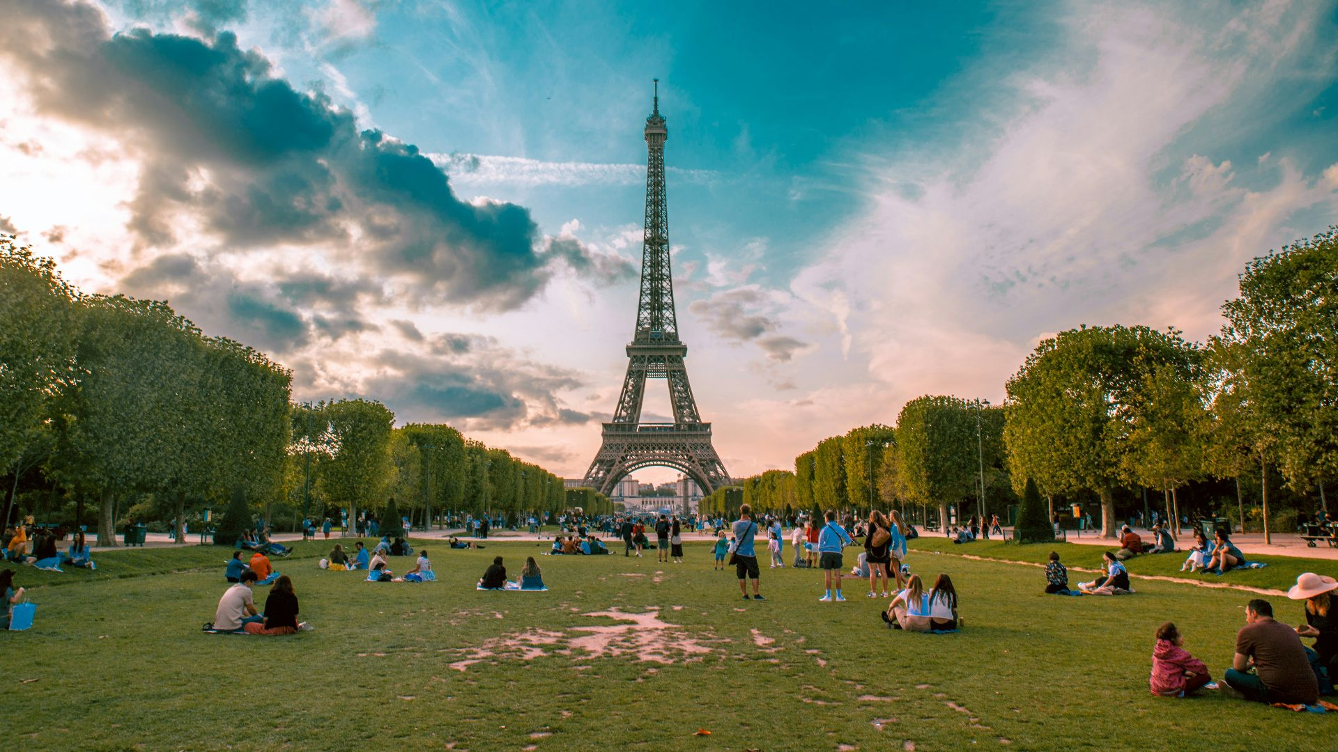 people relaxing near the Eiffel Tower in Paris during the evening