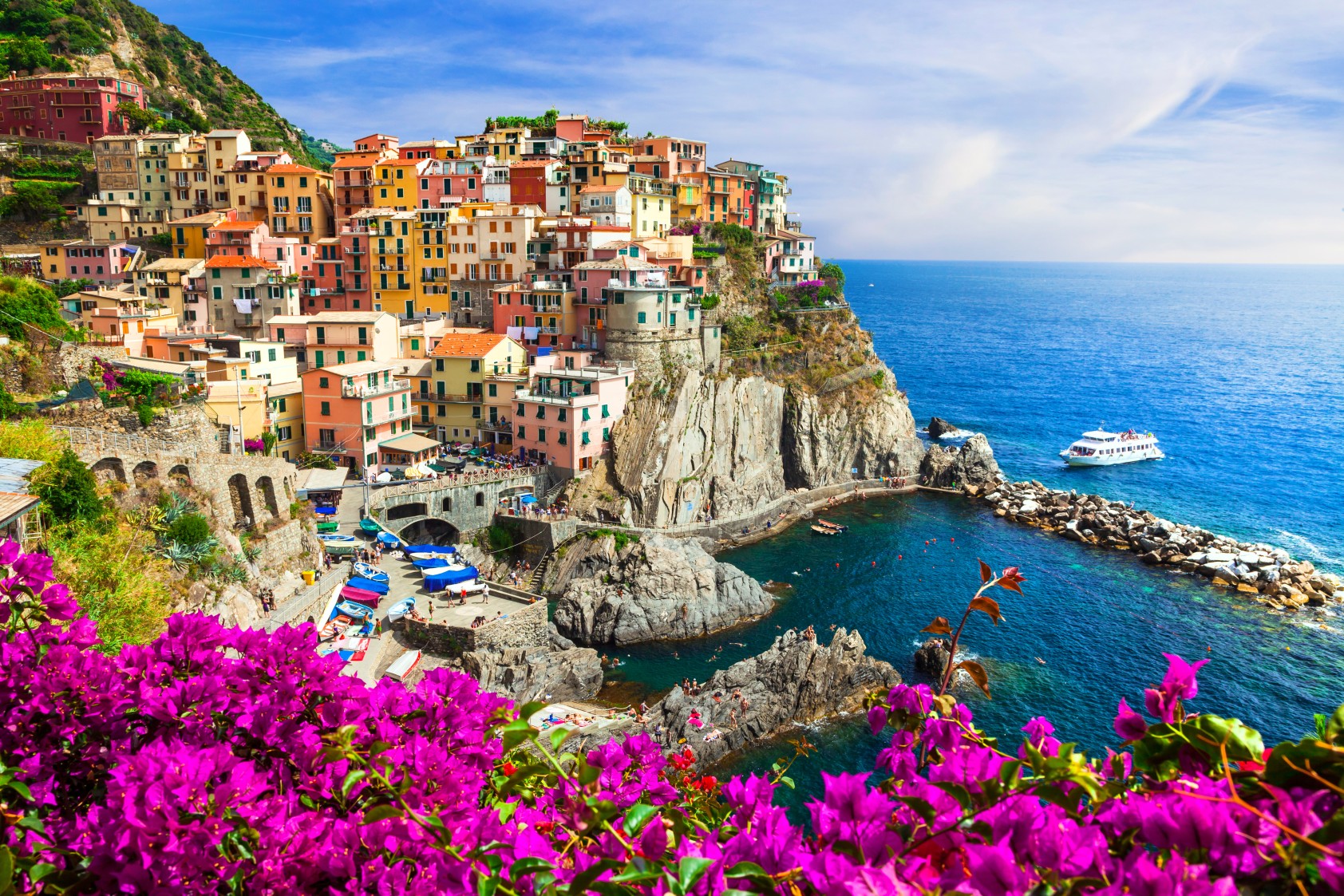 Italy Manarola village in Cinque Terre through pink flowers border. Authentic colorful houses on rocks in Liguria coastal scenery. Traditional Italian architecture UNESCO travel destination Wall art