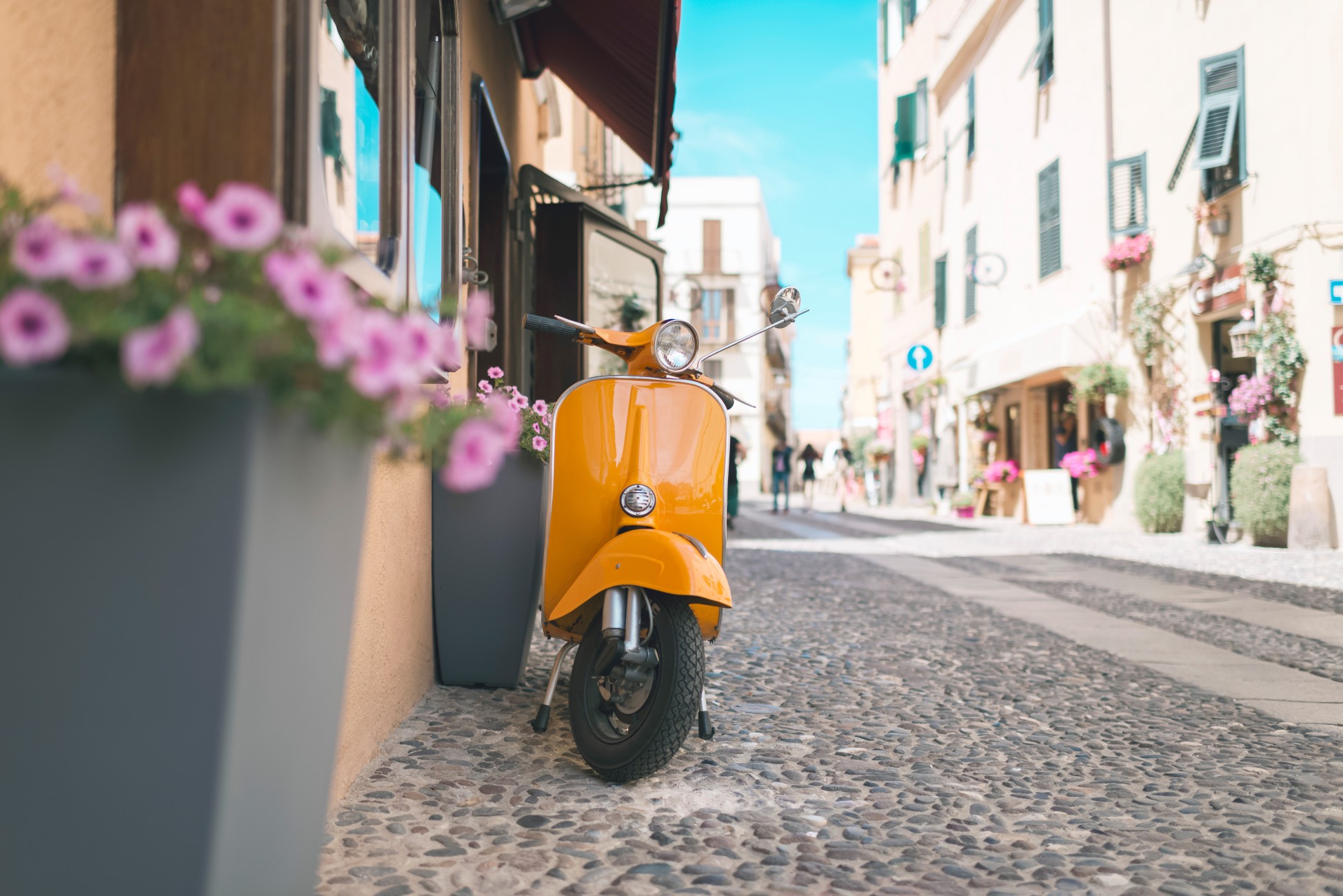 Vintage orange scooter standing in street of Alghero. Sardinia. Italy.