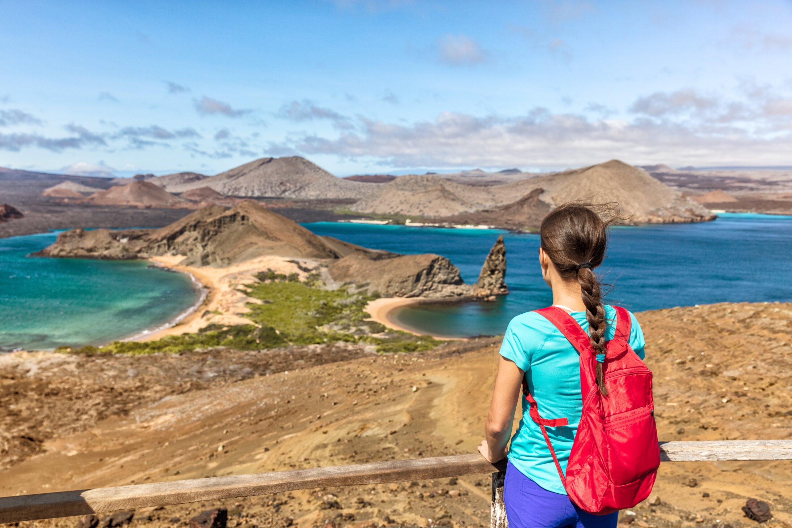 Galapagos islands cruise vacation tourist woman at Bartolome or Bartholomew island view on hiking shore excursion. Hiker Ecuador tourism.
