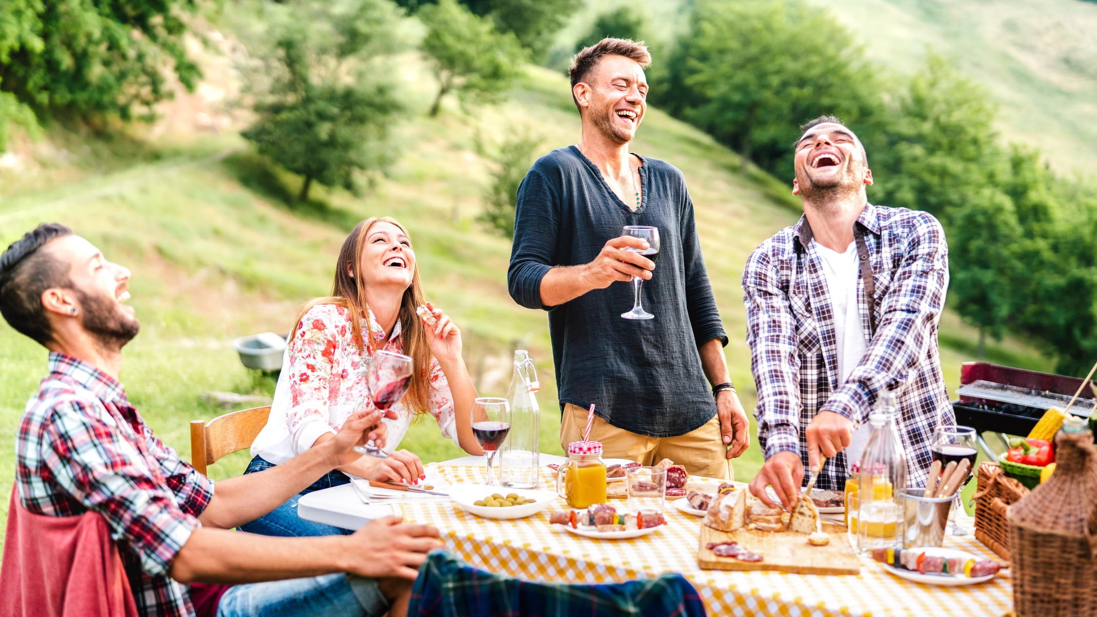 Happy friends group having fun drinking red wine at barbeque pic nic garden party - Young people eating tasty meal at farm house restaurant - Food and beverage life style concept on bright warm filter