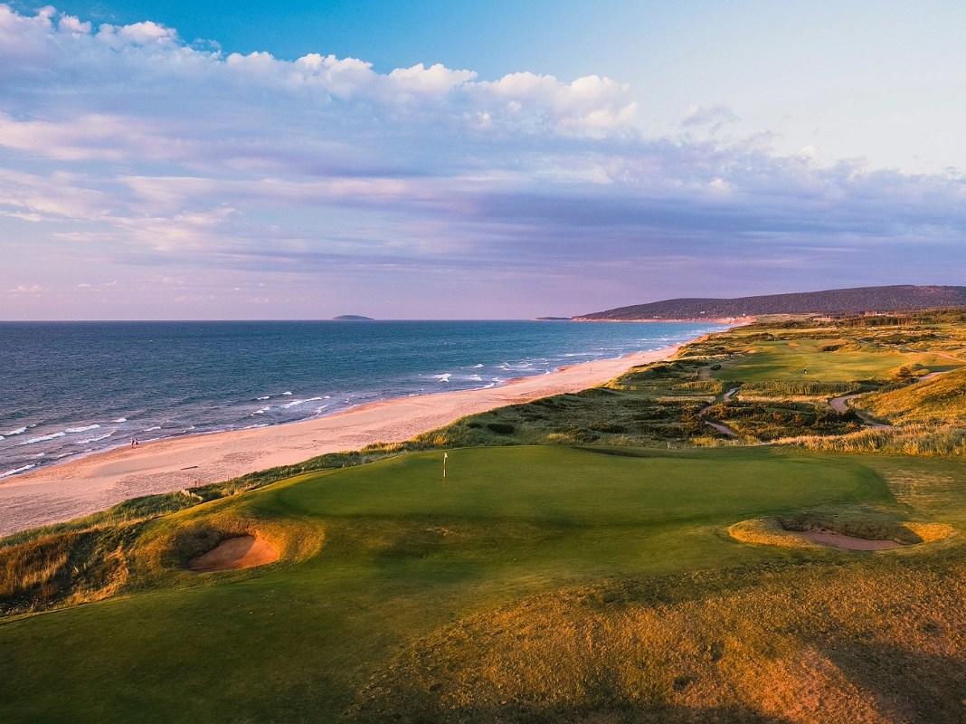 coastal view along the Cabot Trail in Cape Breton with road, cliffs, and ocean at sunset