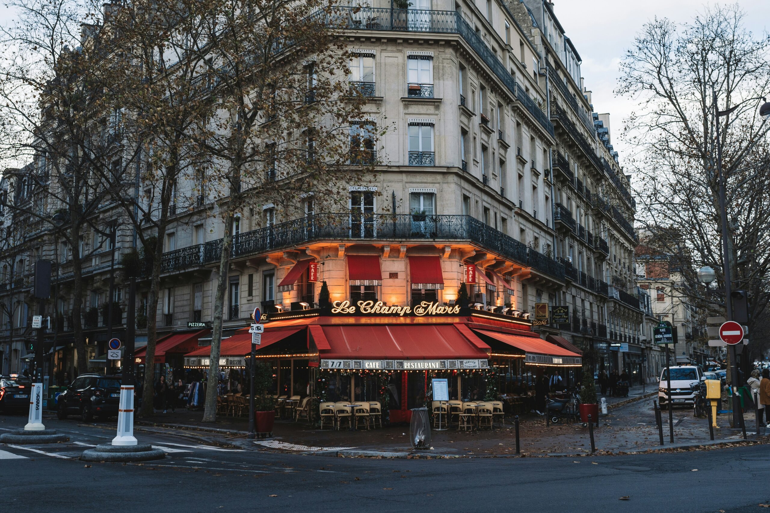 Paris street corner café with outdoor seating and warm evening lights