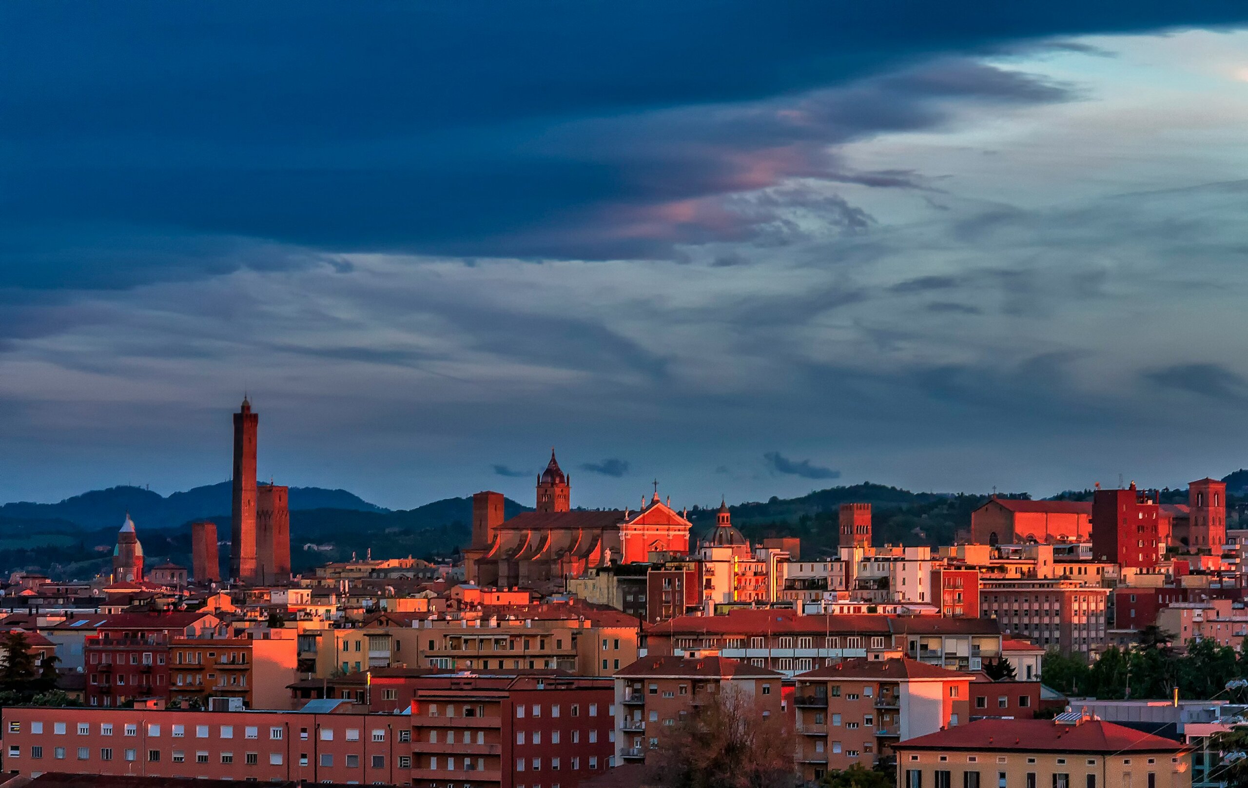 Bologna skyline at sunset with historic towers and red rooftops in Italy