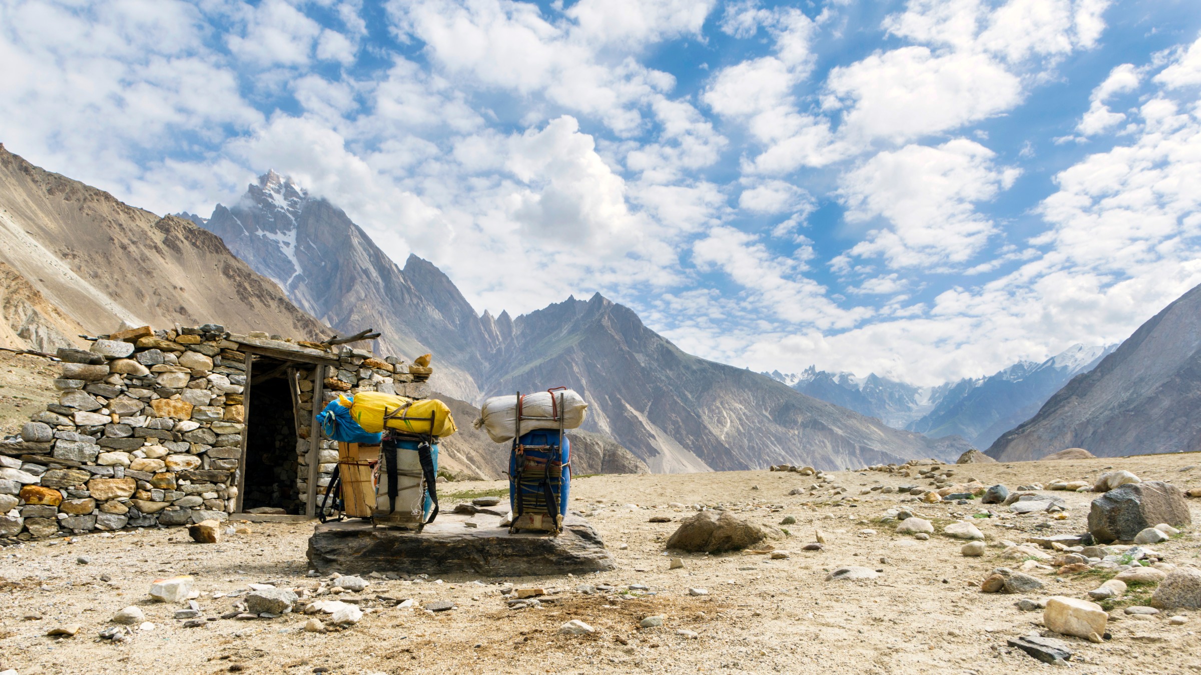 Remote Himalayan mountain base camp beneath dangerous snow-covered peaks
