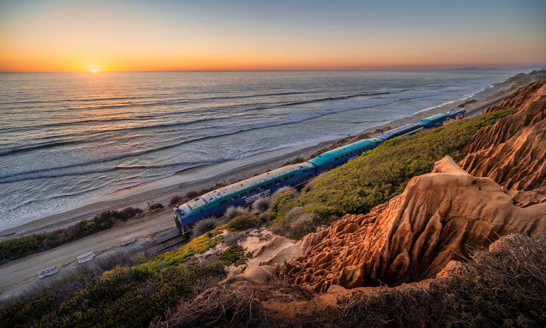 Coastal train ride at sunset for an article about travel destinations for people who hate flying.